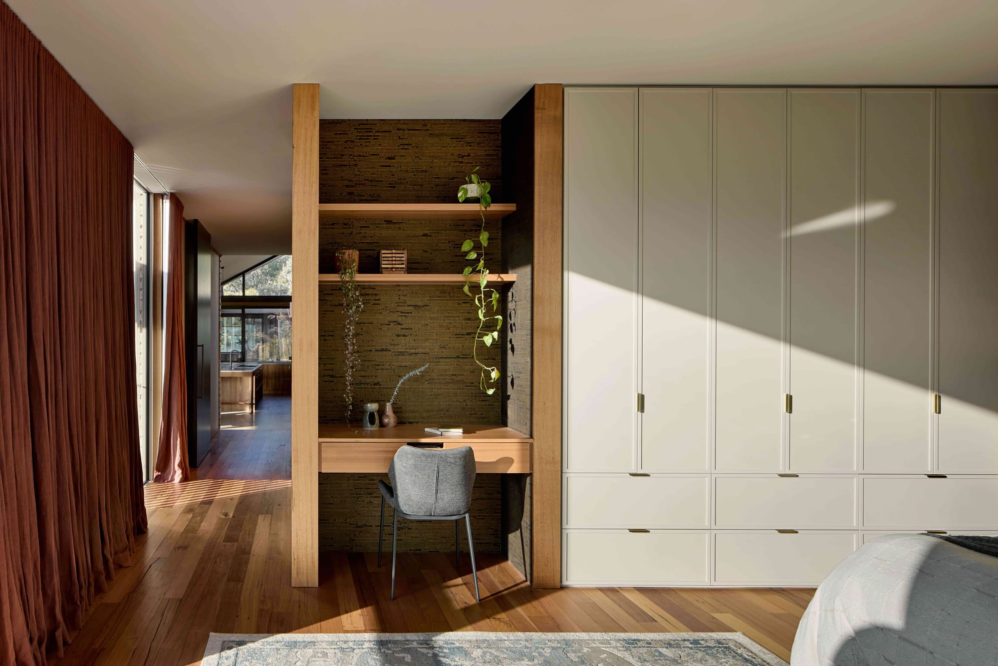 Korinda House by BENT Architecture. Photography by Tatjana Plitt. Integrated study space in white and timber cabinetry running length of wall. 