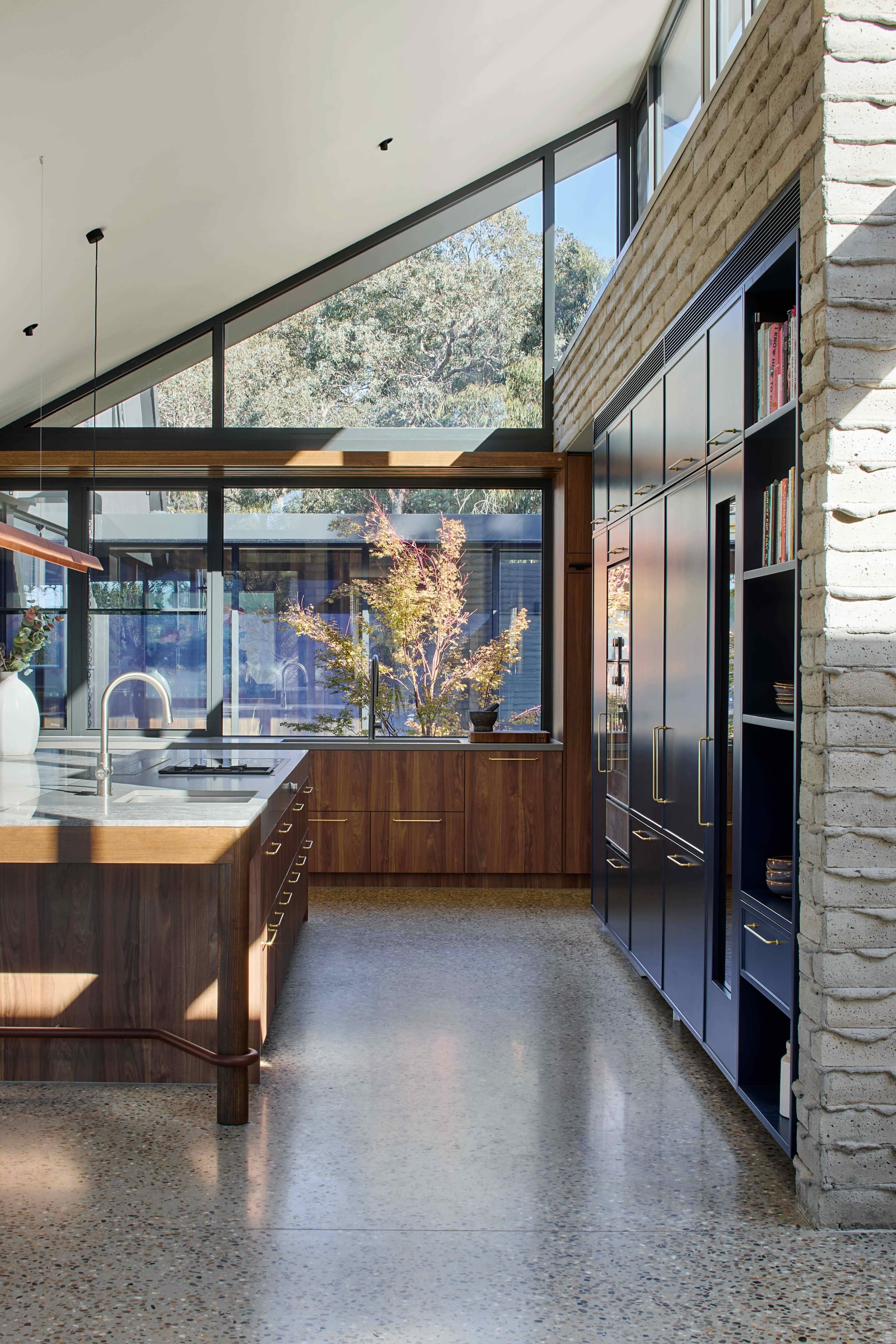 Korinda House by BENT Architecture. Photography by Tatjana Plitt. Kitchen with polished concrete floors, timber and navy blue cabinetry..