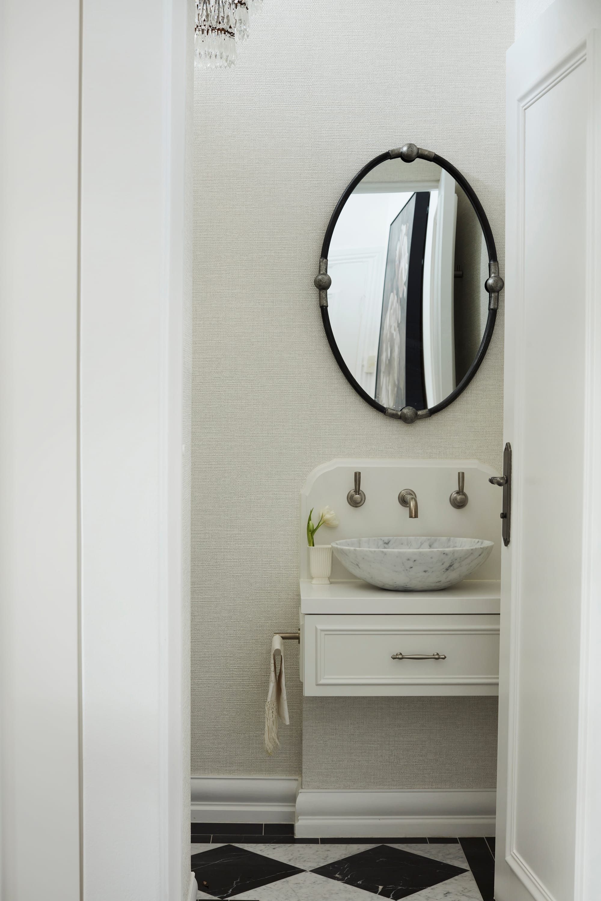 Marathon Road by Marylou Sobel Interior Design. Photography by Prue Ruscoe. Guest bathroom with black and white checkered flooring, white marble basin and black oval mirror.  