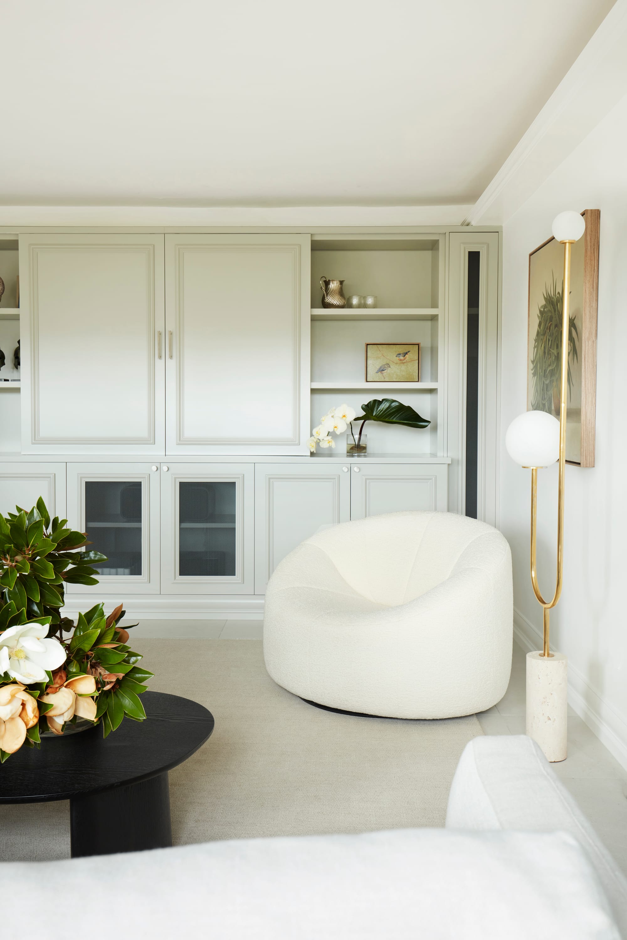 Marathon Road by Marylou Sobel Interior Design. Photography by Prue Ruscoe. Living space with white curved armchair, white carpets, cabinetry and black round coffee table. 