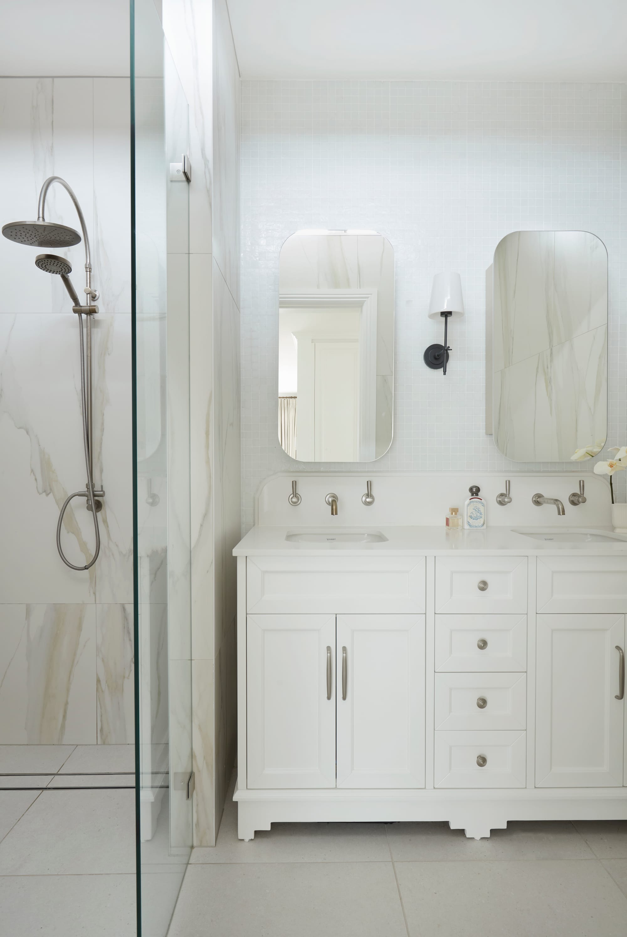 Marathon Road by Marylou Sobel Interior Design. Photography by Prue Ruscoe. White bathroom with white cabinetry, glass shower screen and beige marbled wall tile in shower. 