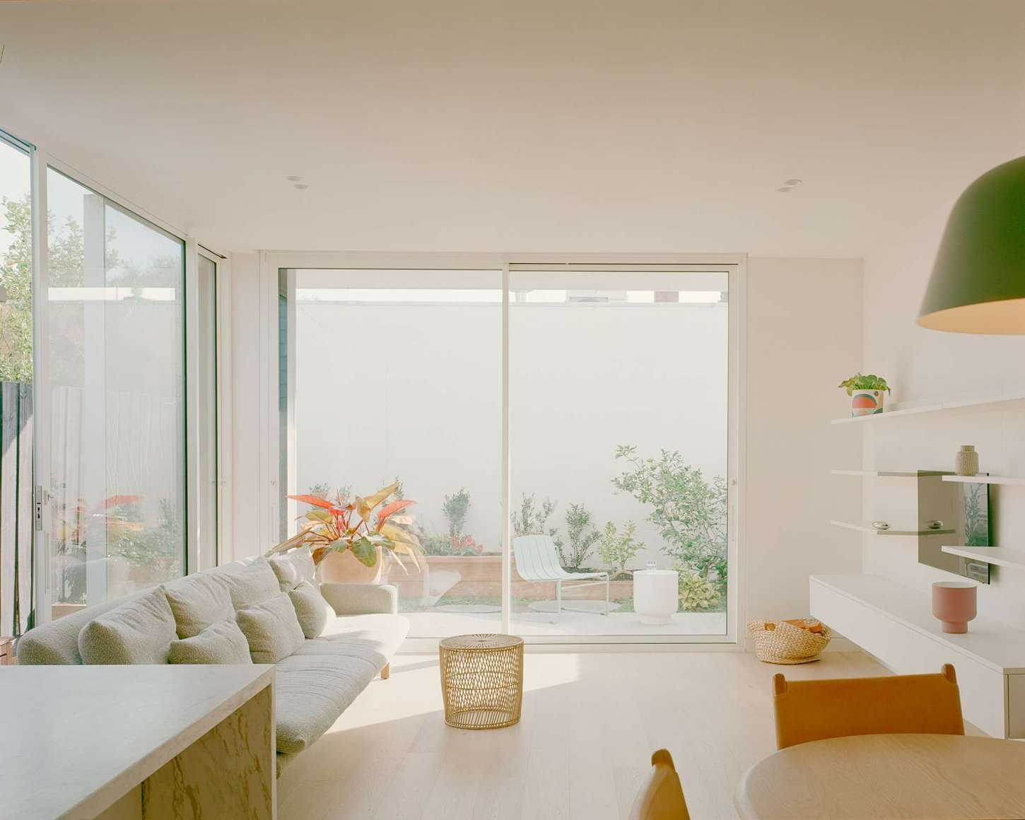 South Yarra Terrace by Emma Tulloch Architects. Photography by Pier Carthew. Light and bright living space with light timber floors, white walls, and full height windowed walls. 