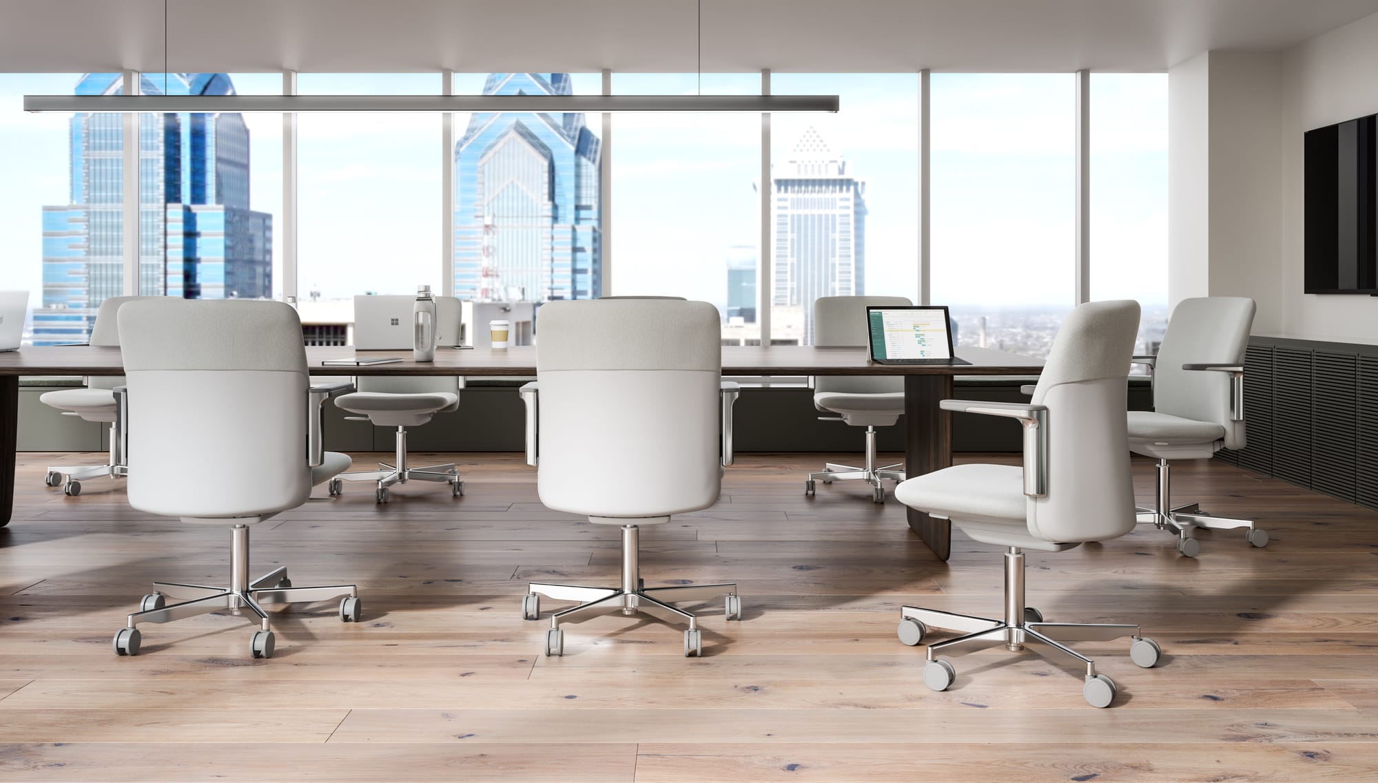 Humanscale, Brand Partner for M&E Interiors. White meeting desk with white chairs in high-rise office space with city views and timber floors. 