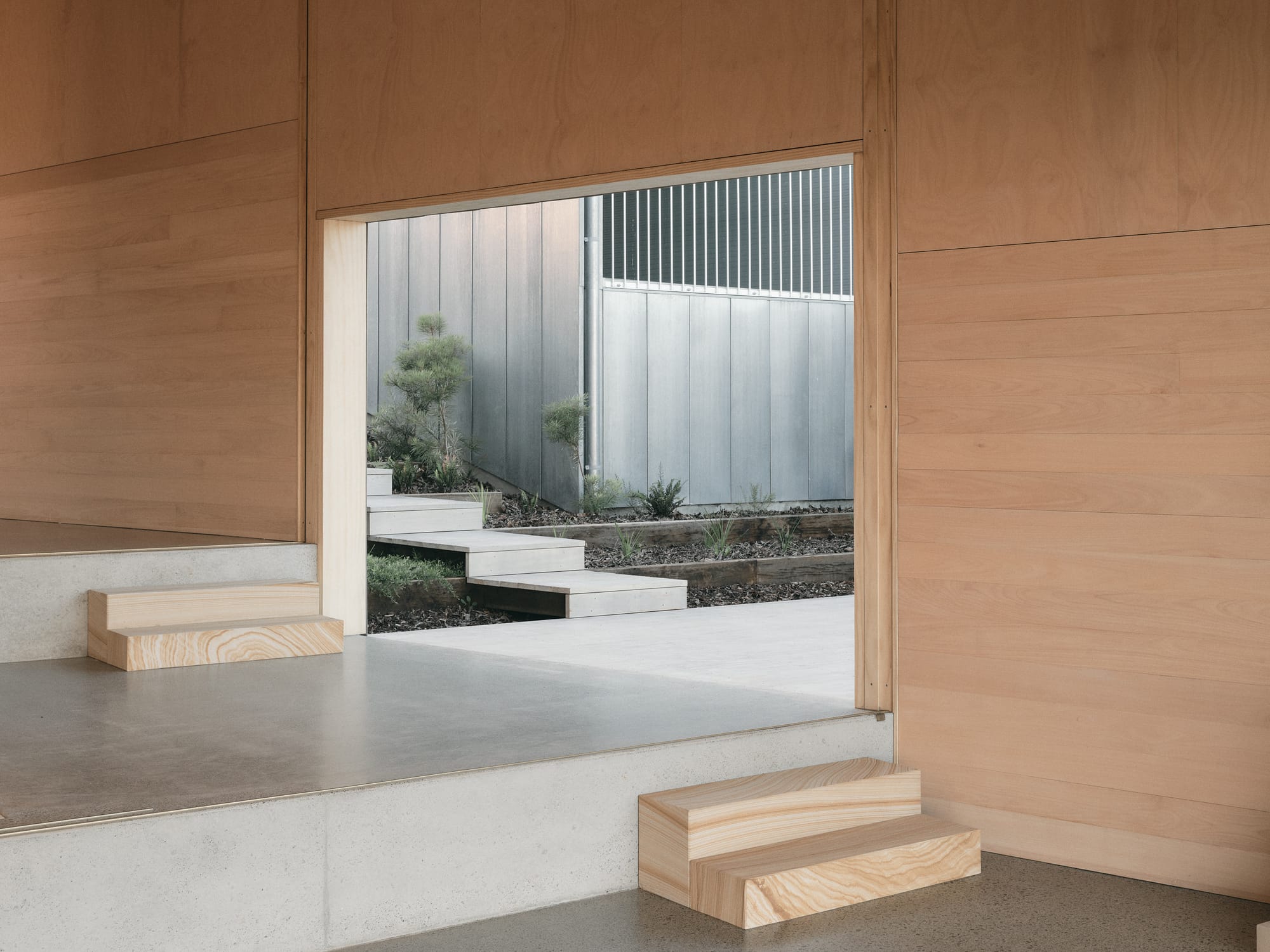Mapleton House by Atelier Chen Hung. Photography by David Chatfield. Stepped interior space with light timber walls and stairs, and polished concrete floors. 