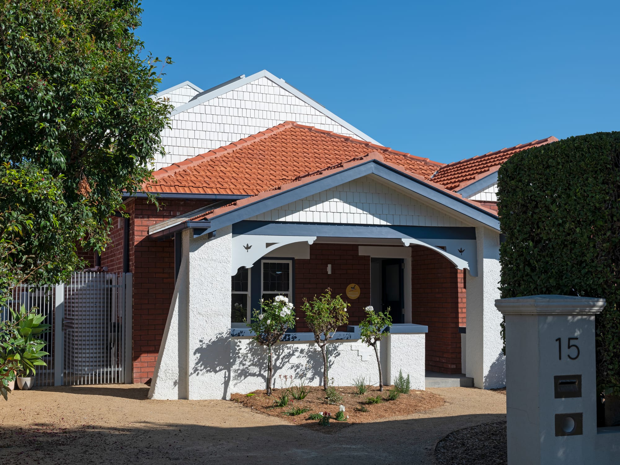 Merrilands by BIJL Architecture. Photography by Tom Ferguson. Home with brick and white render facade, terracotta roof tiles and white clad exterior.