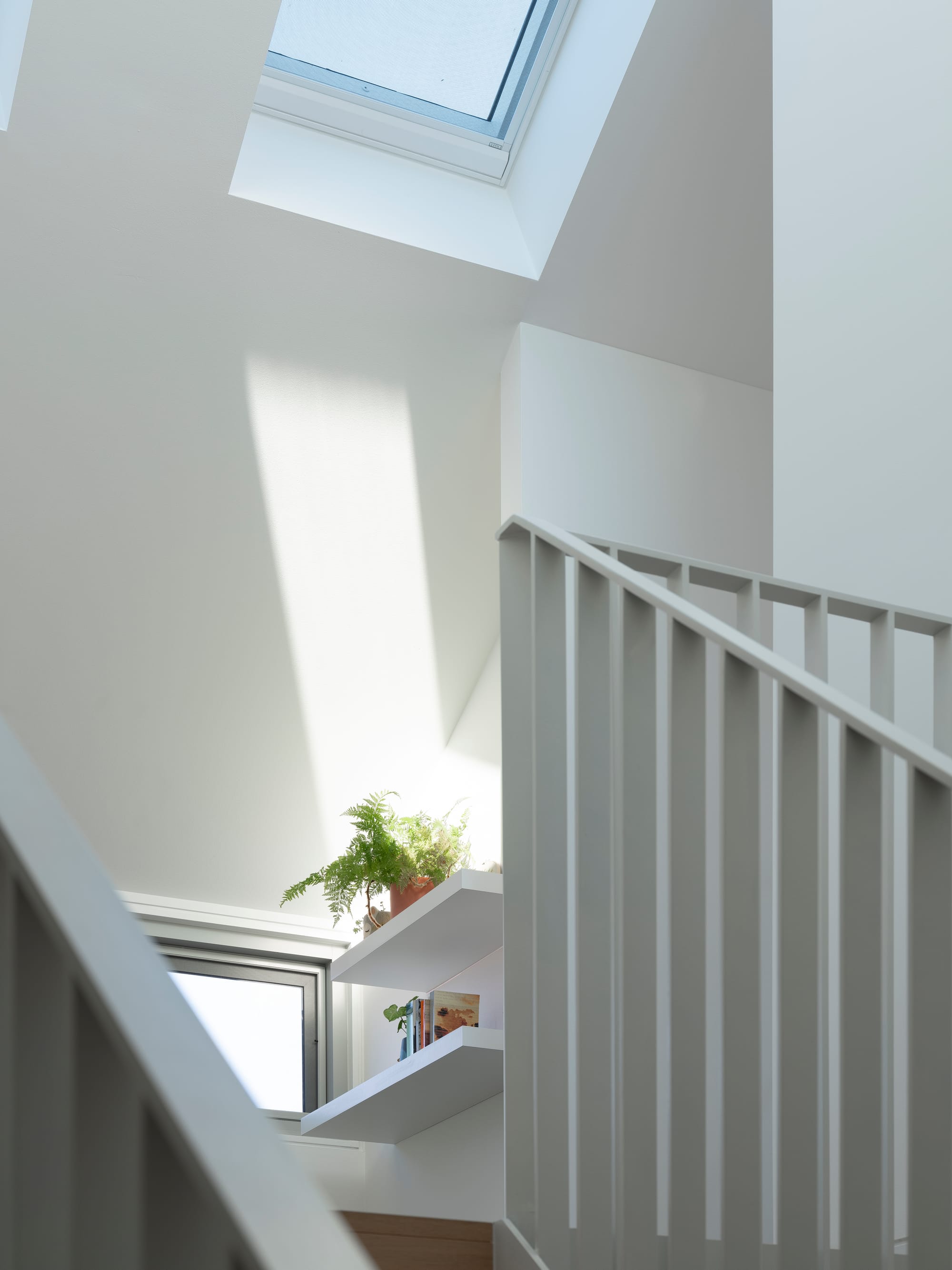 Merrilands by BIJL Architecture. Photography by Tom Ferguson. White floating shelves at top of staircase. 