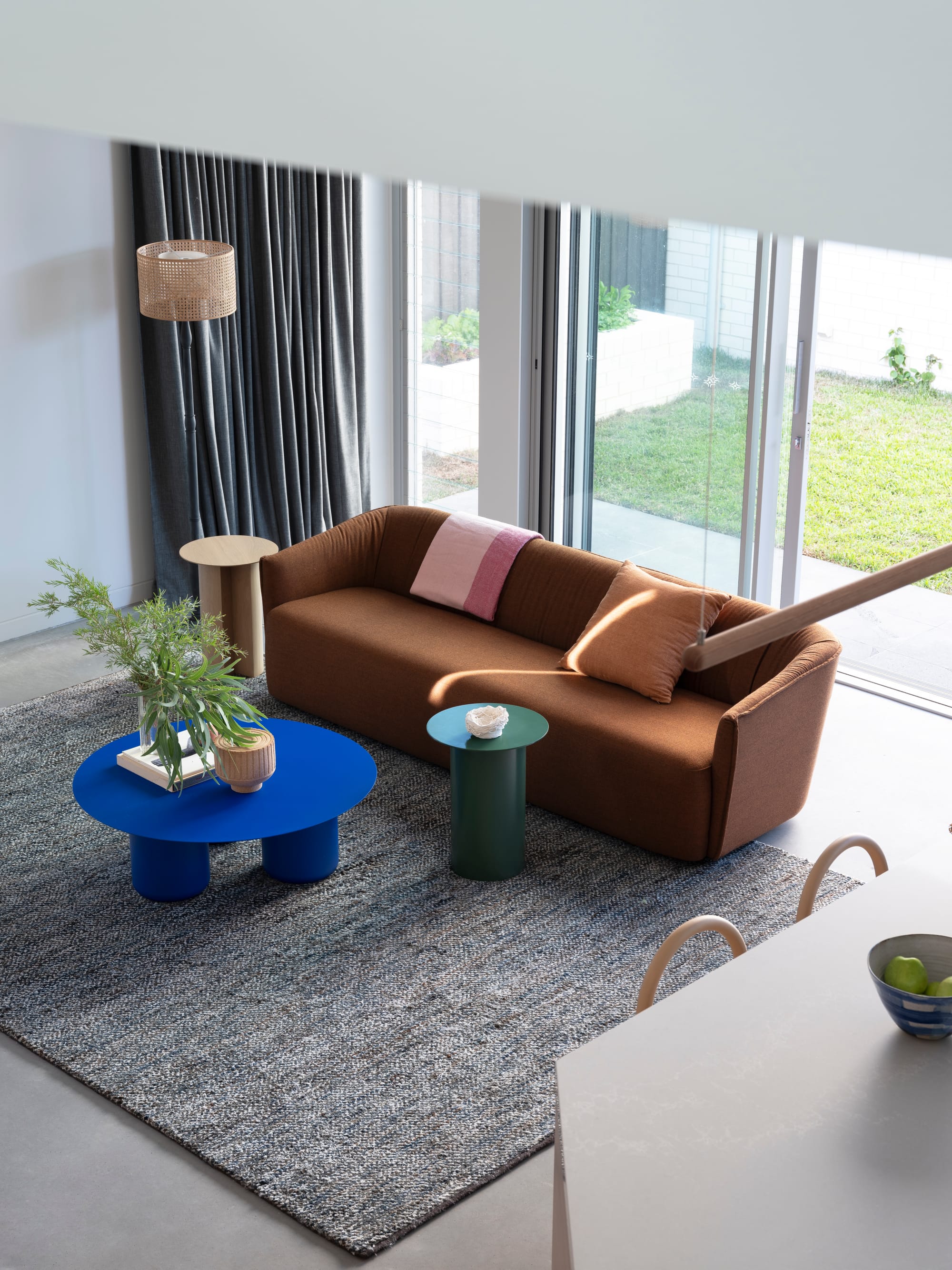 Merrilands by BIJL Architecture. Photography by Tom Ferguson. Living space with brown couch, electric blue coffee table, green and timber end tables and grey rug. 