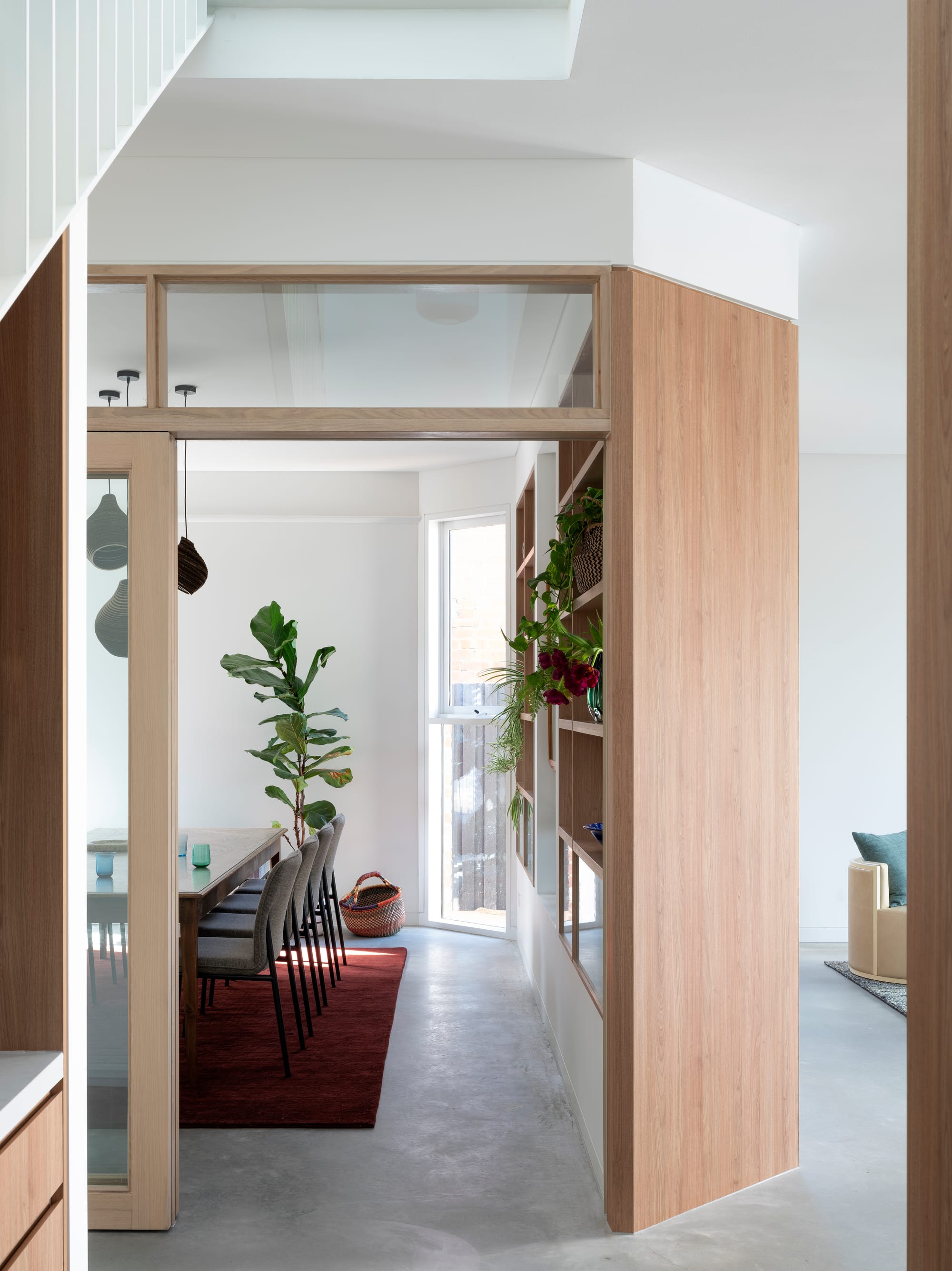 Merrilands by BIJL Architecture. Photography by Tom Ferguson. Enclosed dining space with timber walls, concrete floors, wine red rug and integrated storage. 