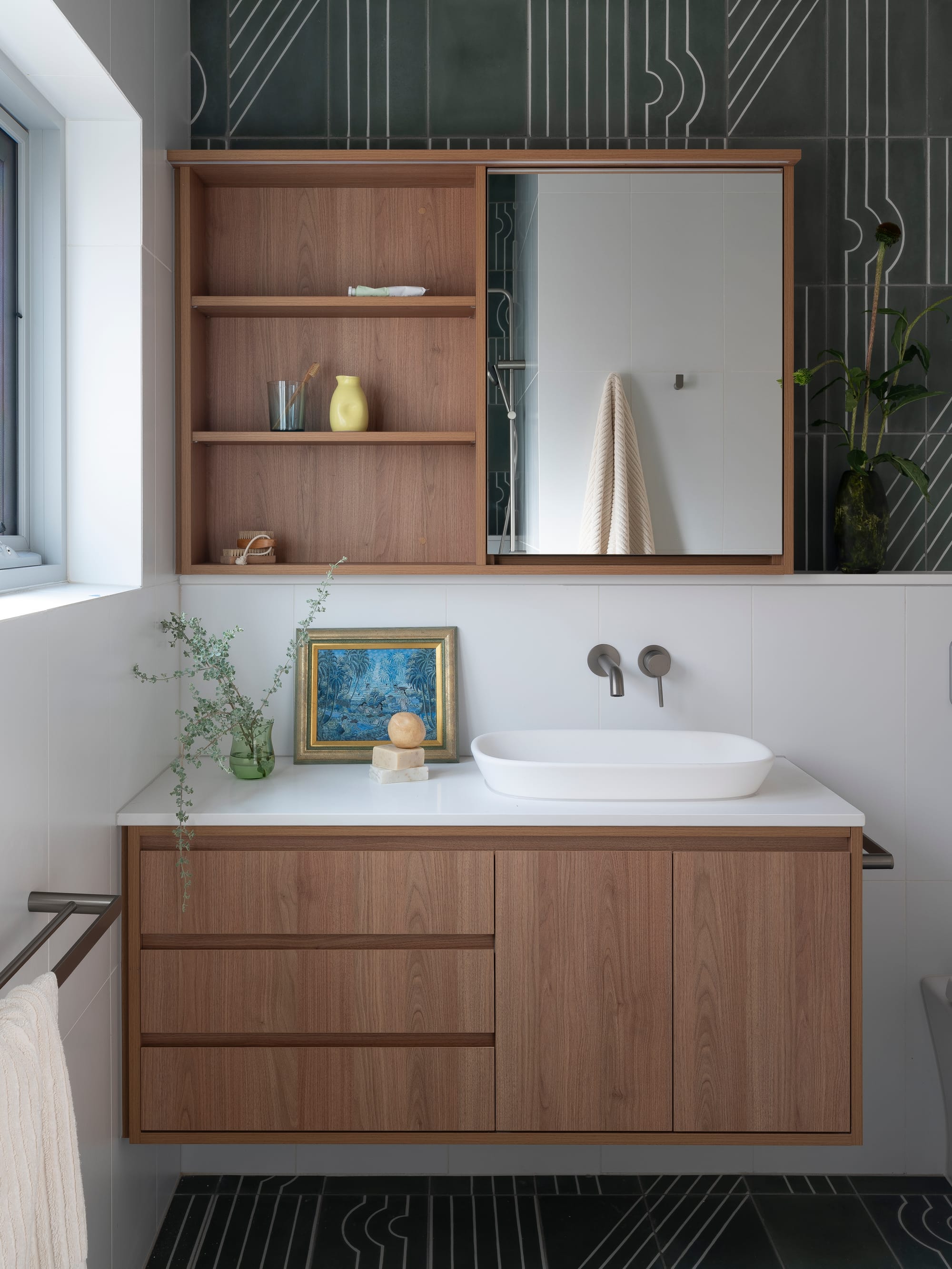 Merrilands by BIJL Architecture. Photography by Tom Ferguson. Bathroom with floating timber vanity, printed black tiles and exposed mirrored storage.