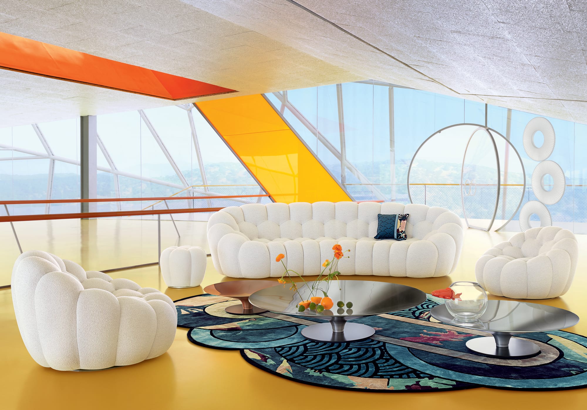 The Lounge Collection by Roche Bobois. Image copyright of Roche Bobois.  Orange, pink, white and blue modular couch on white platform. 