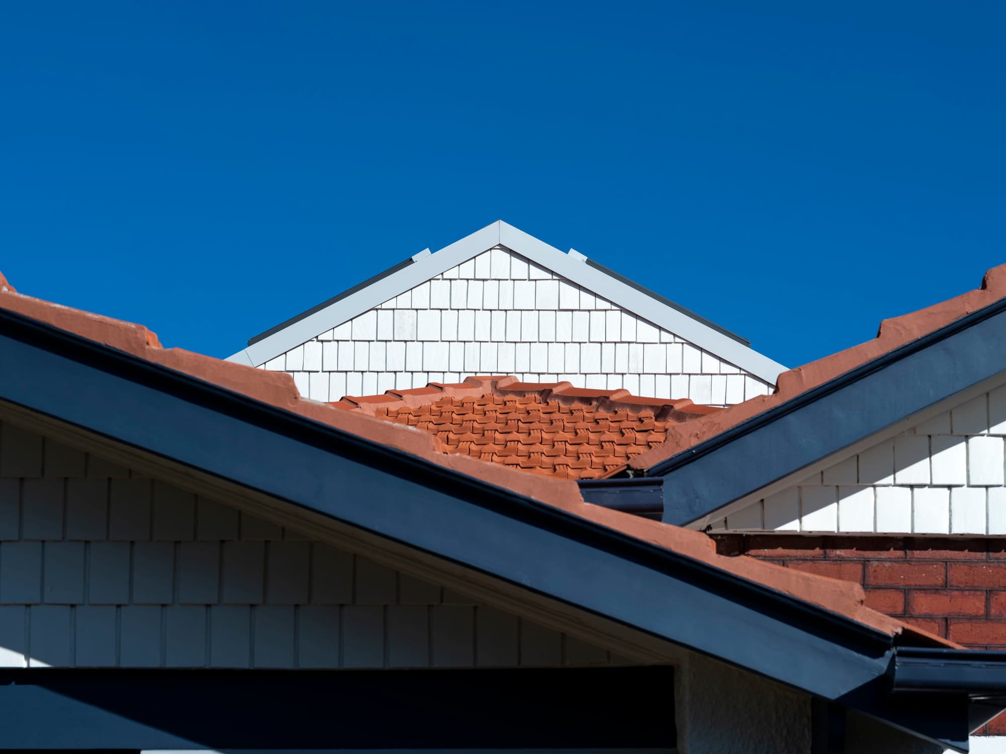 Merrilands by BIJL Architecture. Photography by Tom Ferguson. Enclosed dining space with timber walls, concrete floors, wine red rug and integrated storage. 