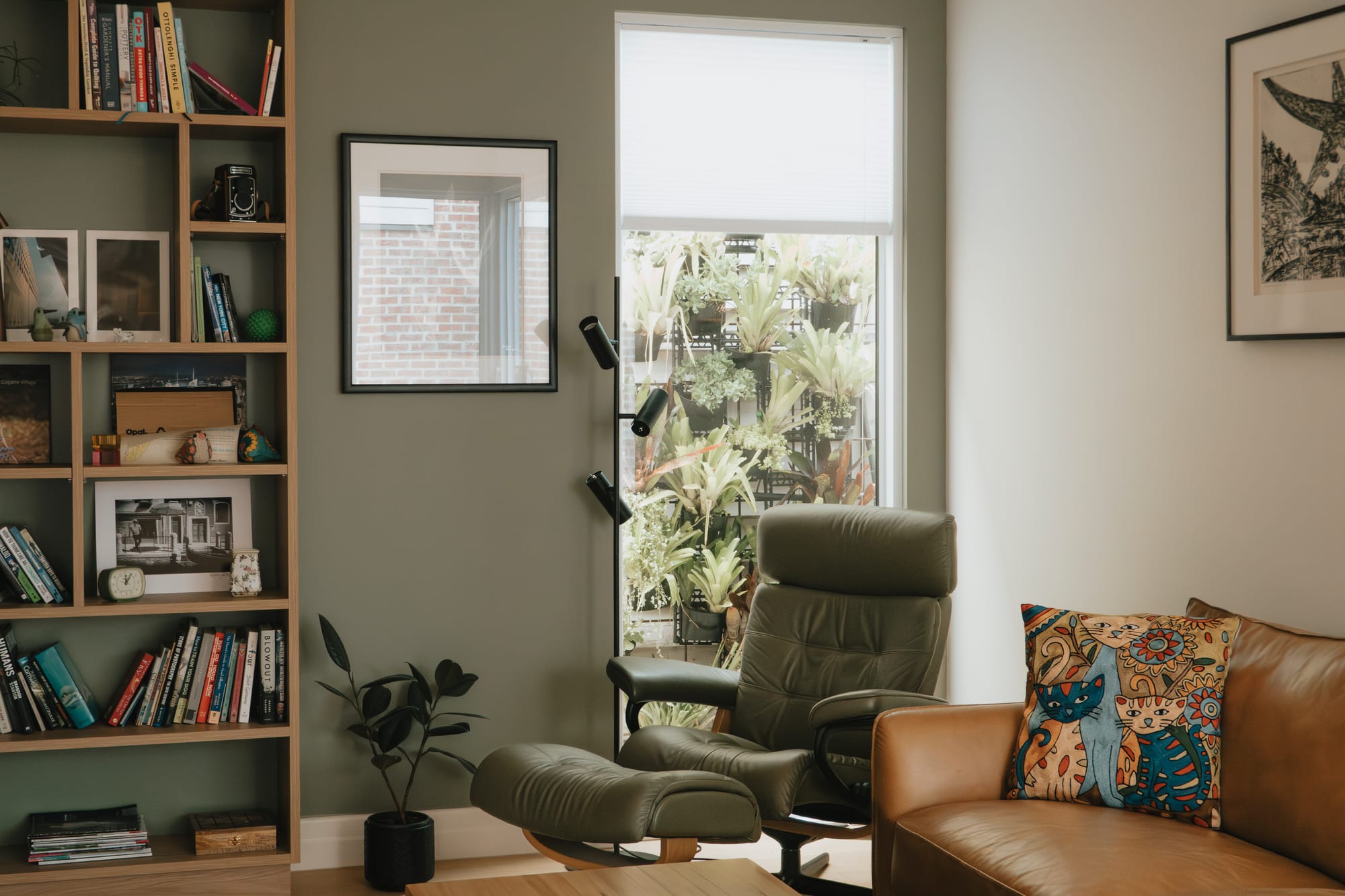 Port Melbourne 2.0 by PREM.BUILT. Image copyright of Prem.Built. Living space with sage green walls, timber cabinetry, and green and brown leather furnishings. 