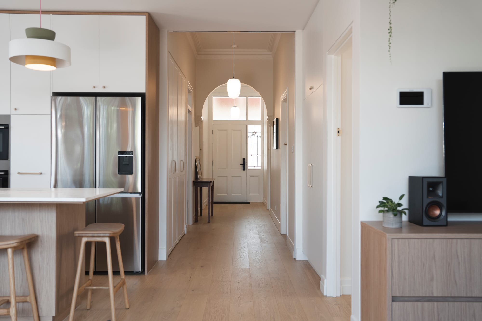 Port Melbourne 2.0 by PREM.BUILT. Image copyright of Prem.Built. Hallway with arches and shaker doors, with kitchen on the left and living space on the right. 