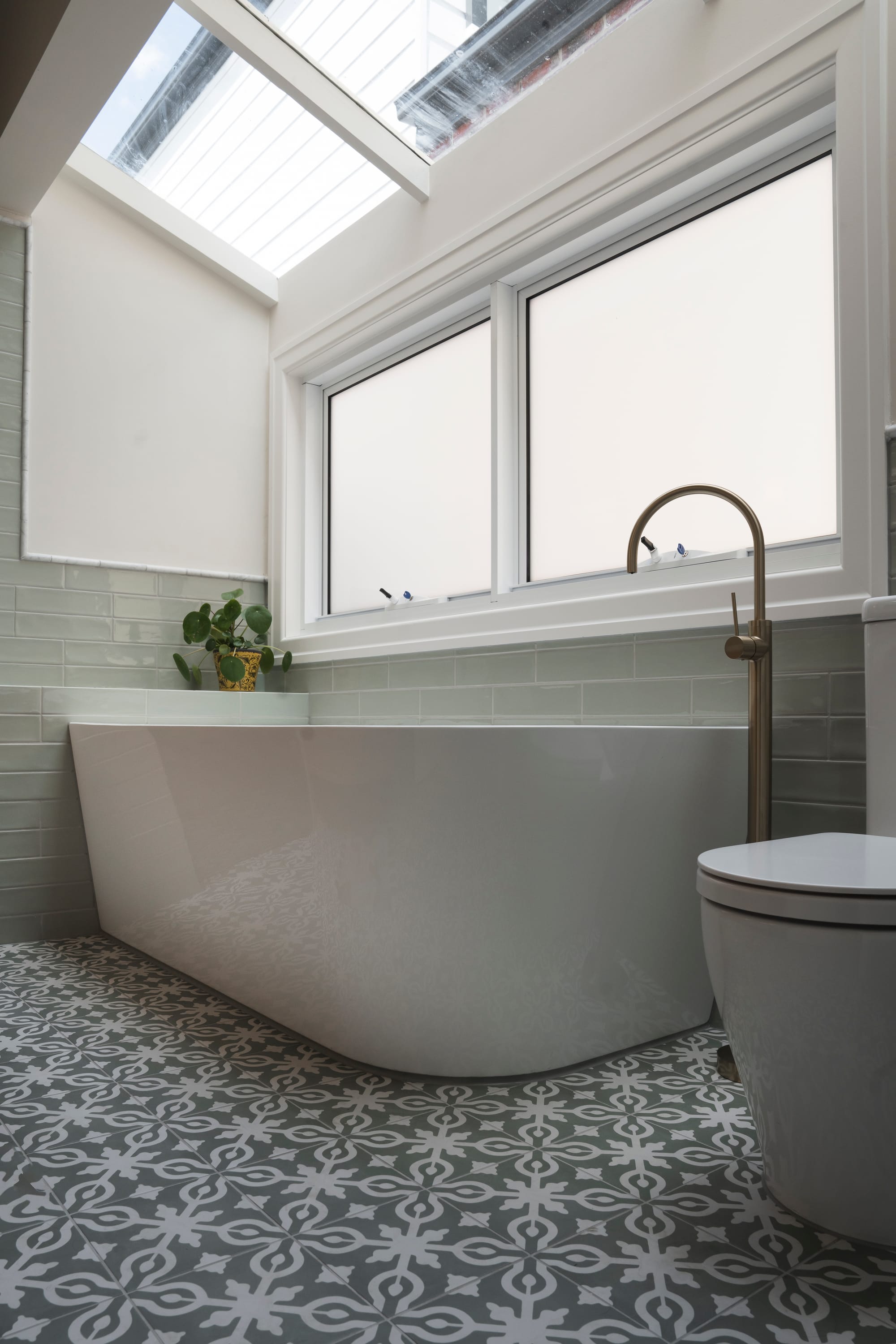 Port Melbourne 2.0 by PREM.BUILT. Image copyright of Prem.Built. Bathroom with patterned floor tiles, sage green wall tiles, freestanding white bathtub and large white window. 