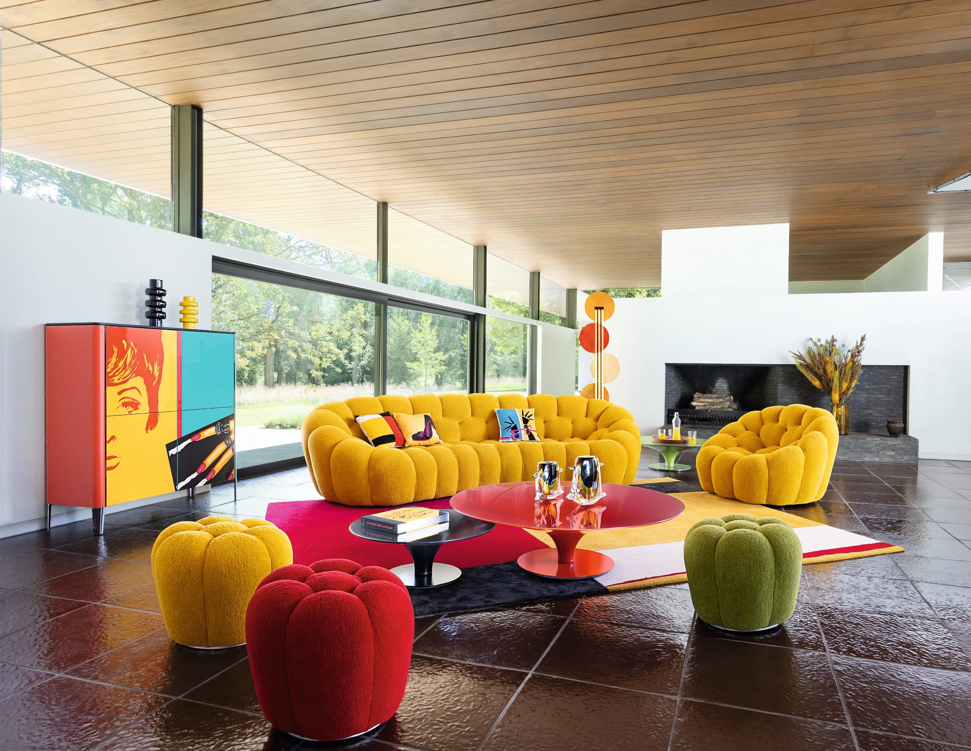 Bubble Collection by Roche Bobois. Image copyright of Roche Bobois. Yellow bubble couch with matching armchair and poufs in yellow, red and green in space with burgundy floor tiles. 