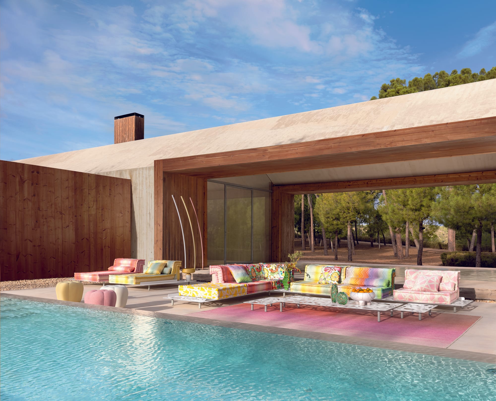 The Lounge Collection by Roche Bobois. Image copyright of Roche Bobois. White boucle sofa with red, yellow and blue coffee table and large rug in primary colours. 