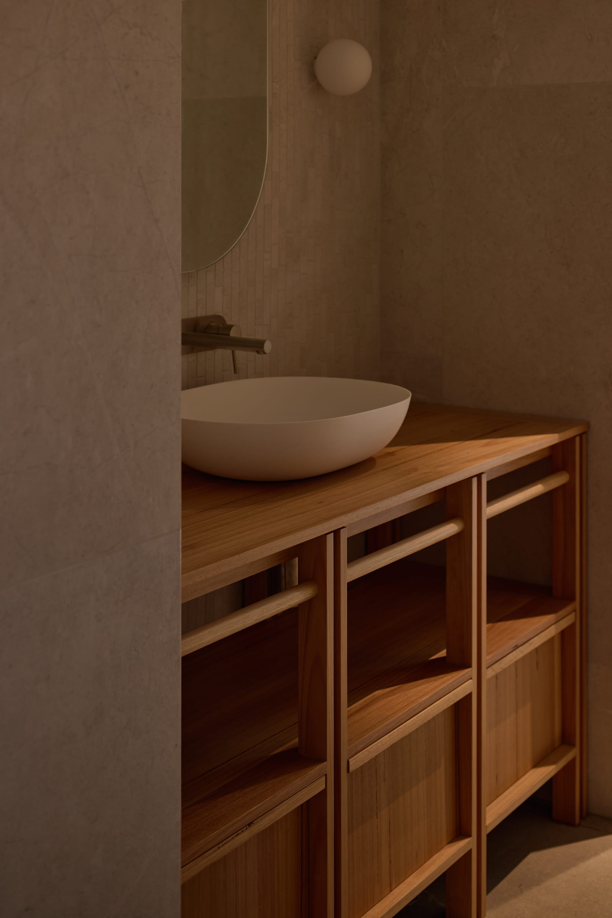 Binnum Homestead by Alexandra Buchanan Architecture. Photography by Cieran Murphy. Timber cabinet with freestanding white basin on top, in bathroom with tiled walls and floors.  