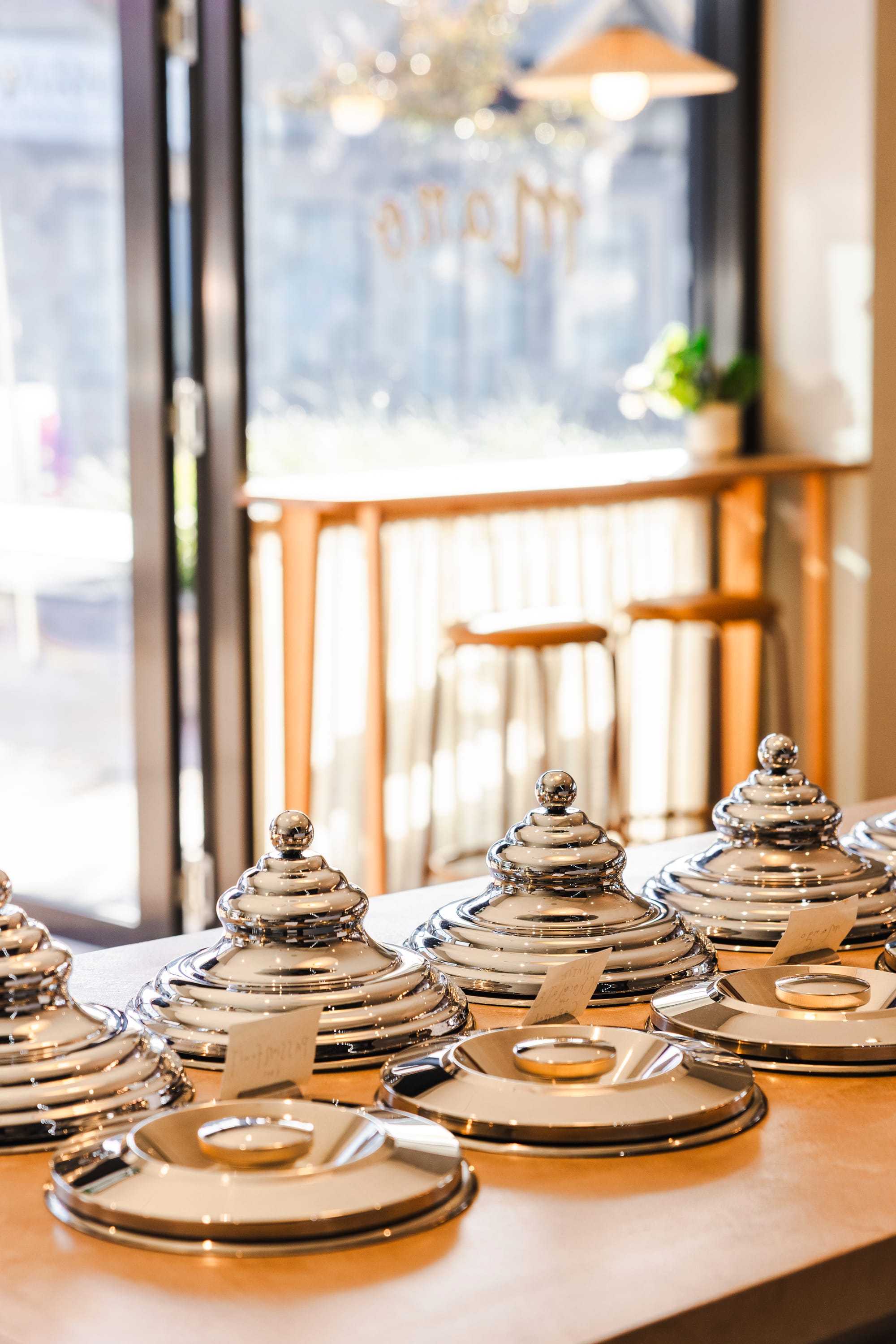 The Cafe by Bel.Bon Design. Photography by Sana Brotherson. Chrome ice cream vat lids inlaid into concrete countertop. 