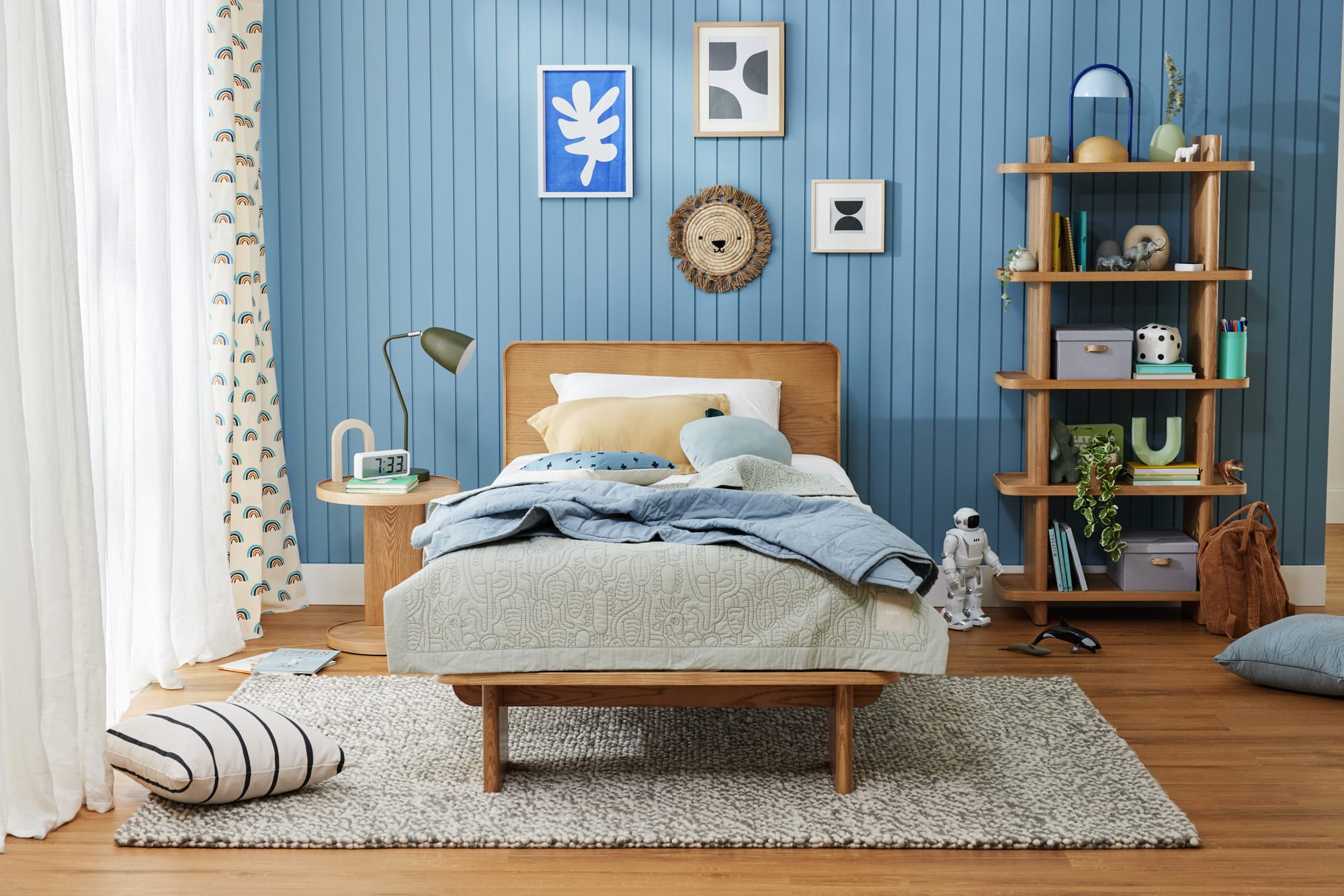 Kirribilli Bed Frame by Koala. Timber bedframe in room with timber flooring, grey rug and blue paneled walls. 