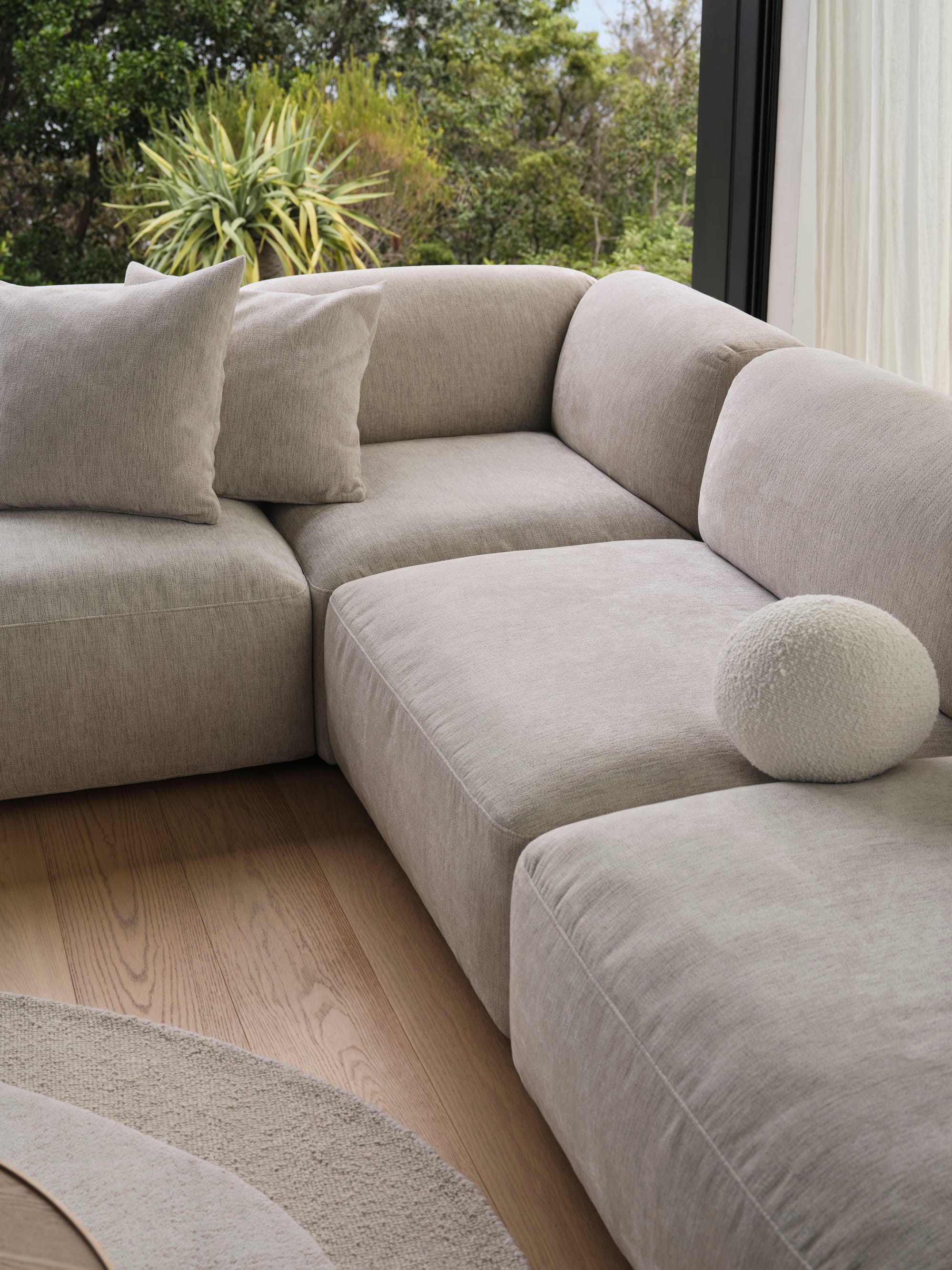 Torquay Sofa in Silver Sand by Koala. Light grey modular sofa in room with timber floors and a beige rug. 