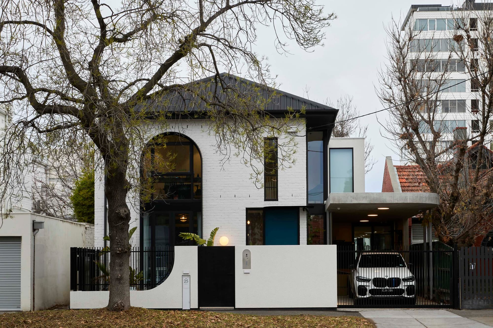Park St by SGKS ARCH. Photography by Tania Lee. Hallway with concrete floors, peach walls and metal staircase.