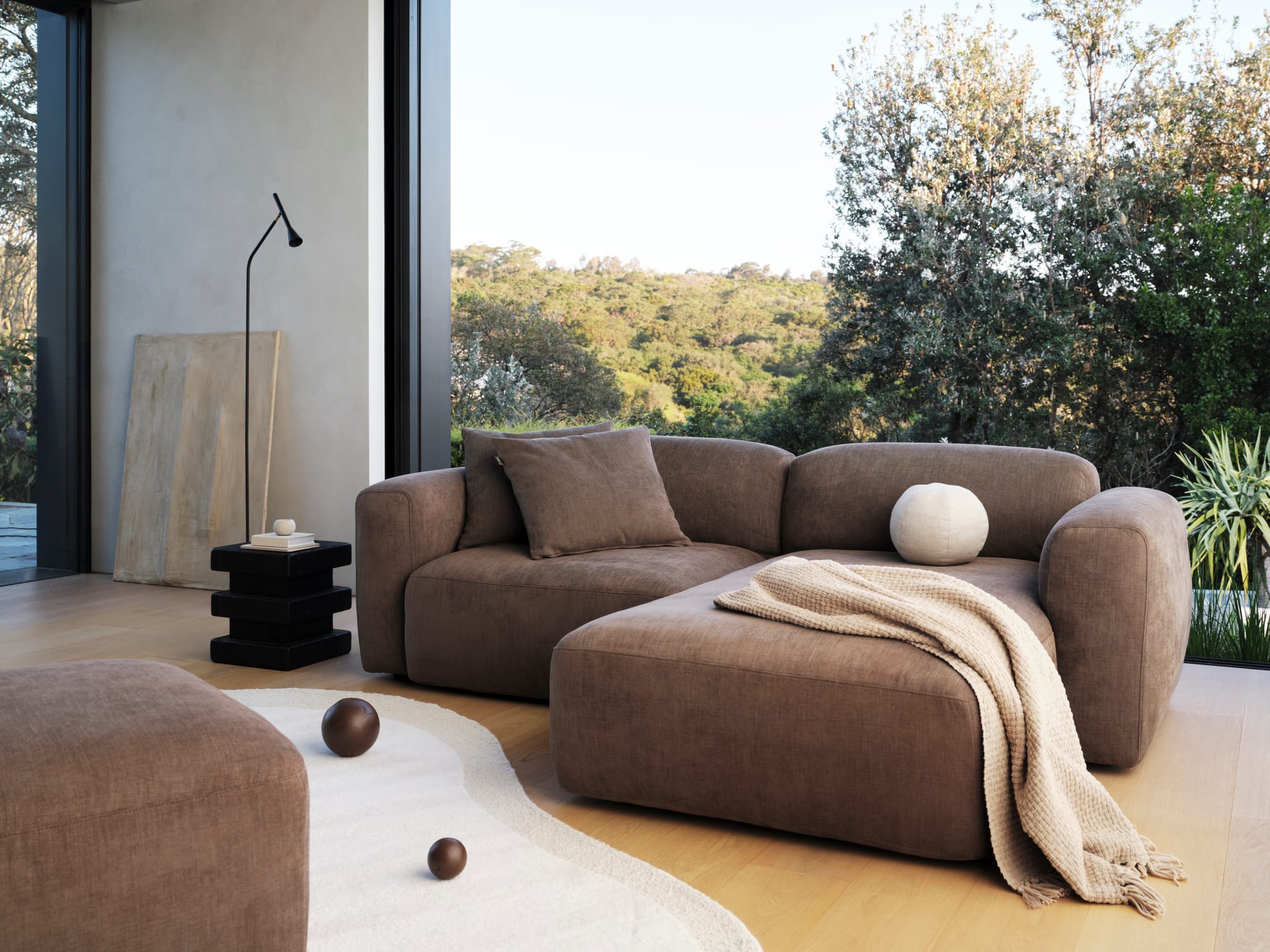Koala's Torquay Modular Sofa Bed in Midnight Mocha in a modern living room with a big window.