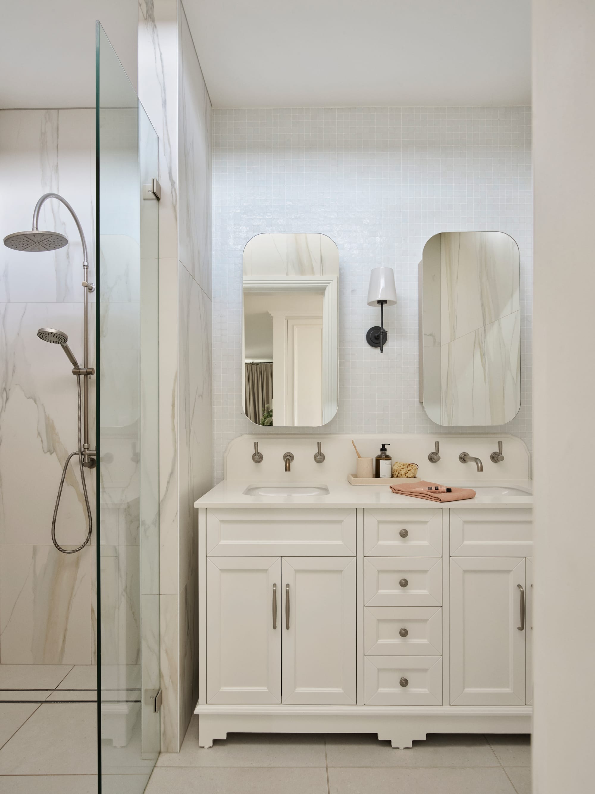 The Darling Edit by Marylou Sobel Interior Design. Photography by Anson Smart. Bathroom with double white vanity, white tiled walls and marble shower. 