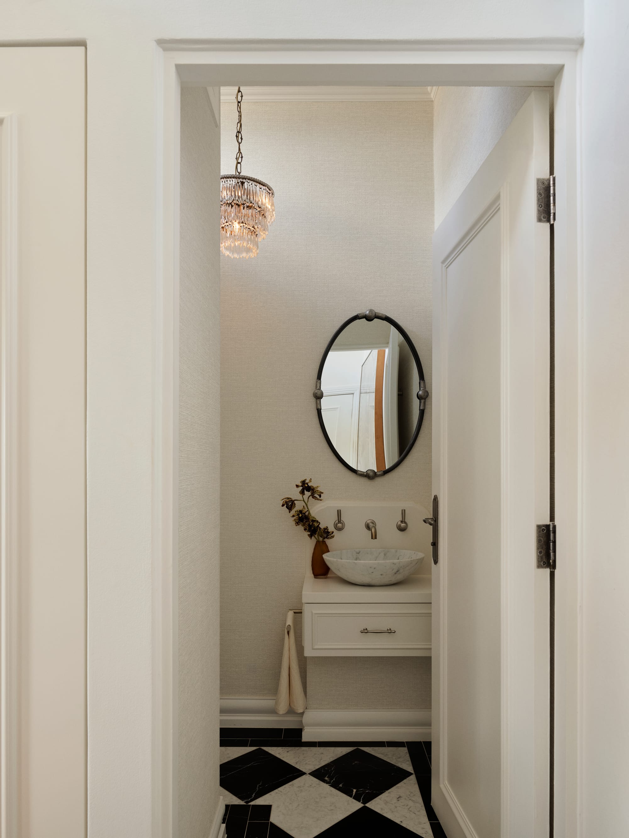 The Darling Edit by Marylou Sobel Interior Design. Photography by Anson Smart. Bathroom with wallpapered walls, floating white basin, white marble sink and black mirror.