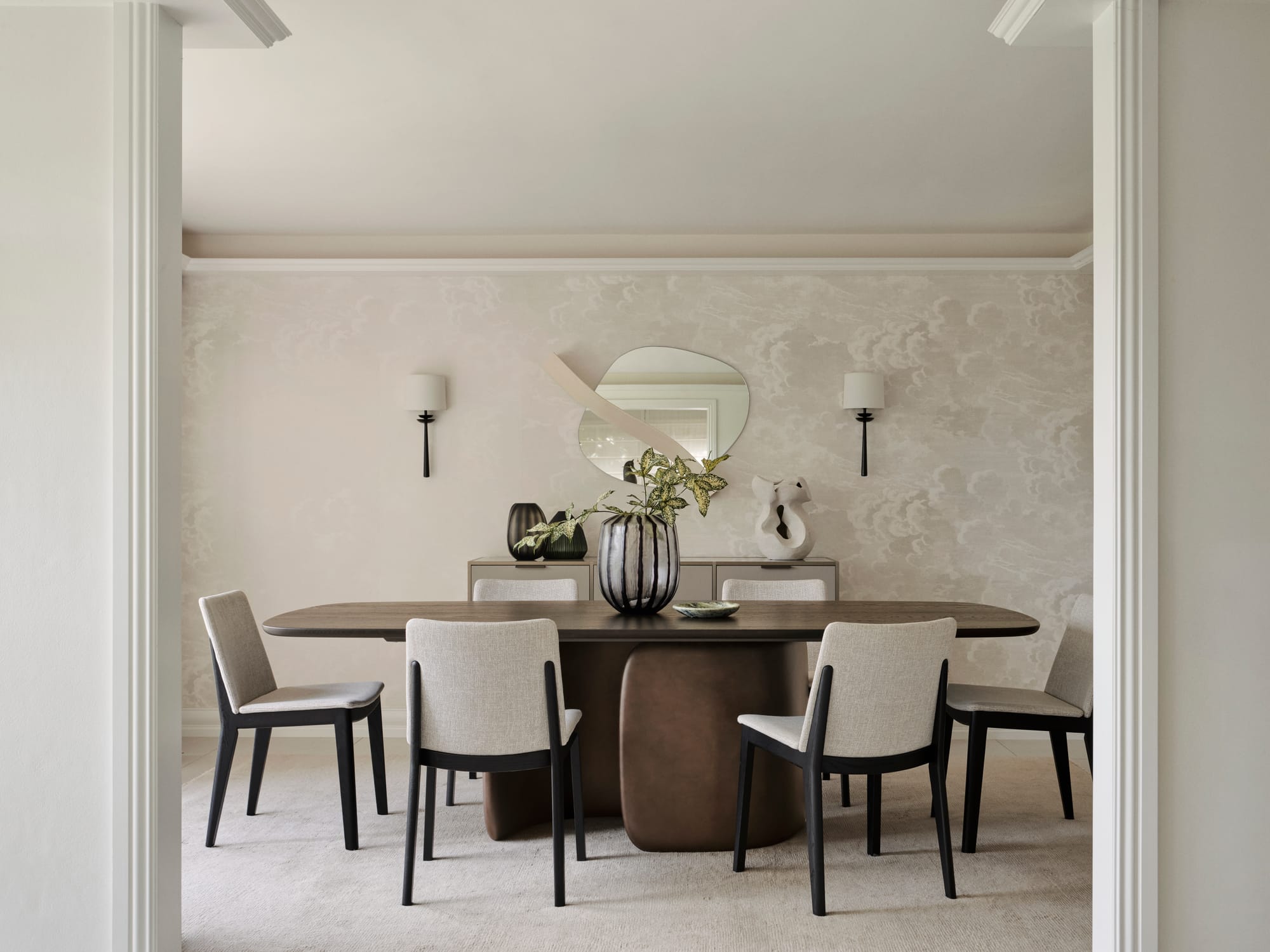 The Darling Edit by Marylou Sobel Interior Design. Photography by Anson Smart. Dining room with fabric chairs and abstract dark timber table framed by white doorway. 