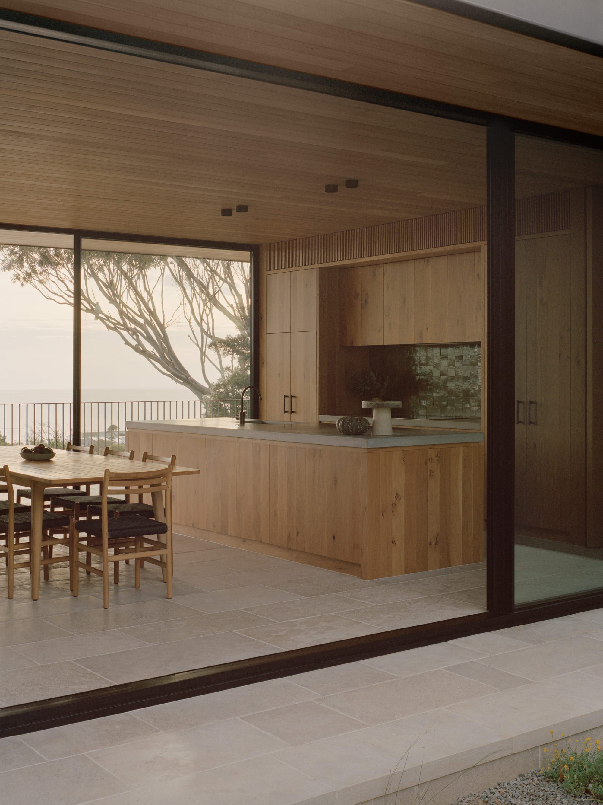Anglesea House by Eckersley Architects. Photography by Tasha Tylee. Full-height glass openings frame open plan kitchen and dining space. 