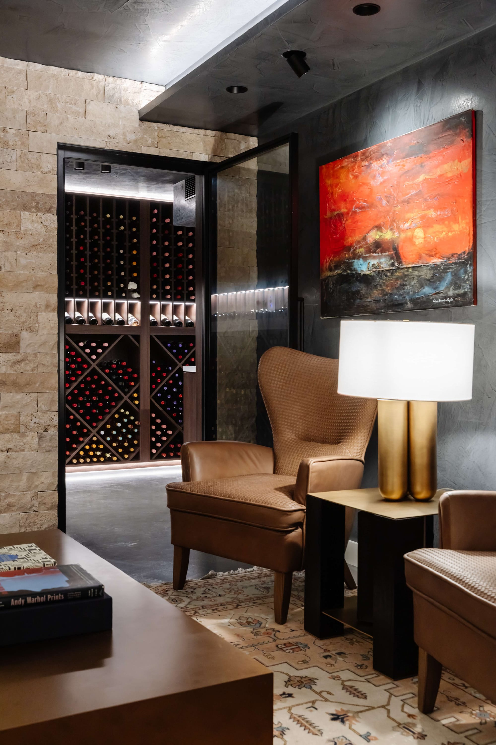 Avalon Beach Wine Cellar & Lounge by Nx Studio. Photography by REM Design House. Brown leather armchairs on patterned rug with brass lamp and wine cellar in background. 