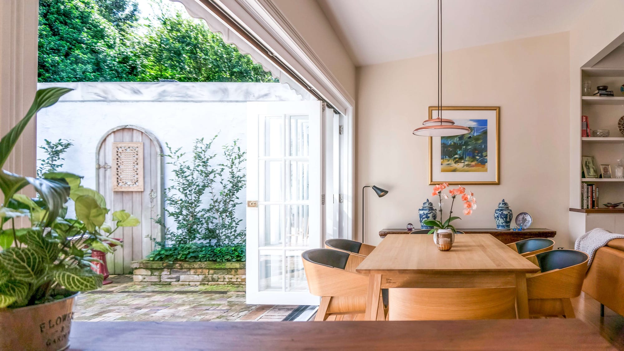 Balmain House by Nx Studio. Photograohy by Gretchen Chappelle. Open plan dining area extending into outdoor courtyard with paved floors. 