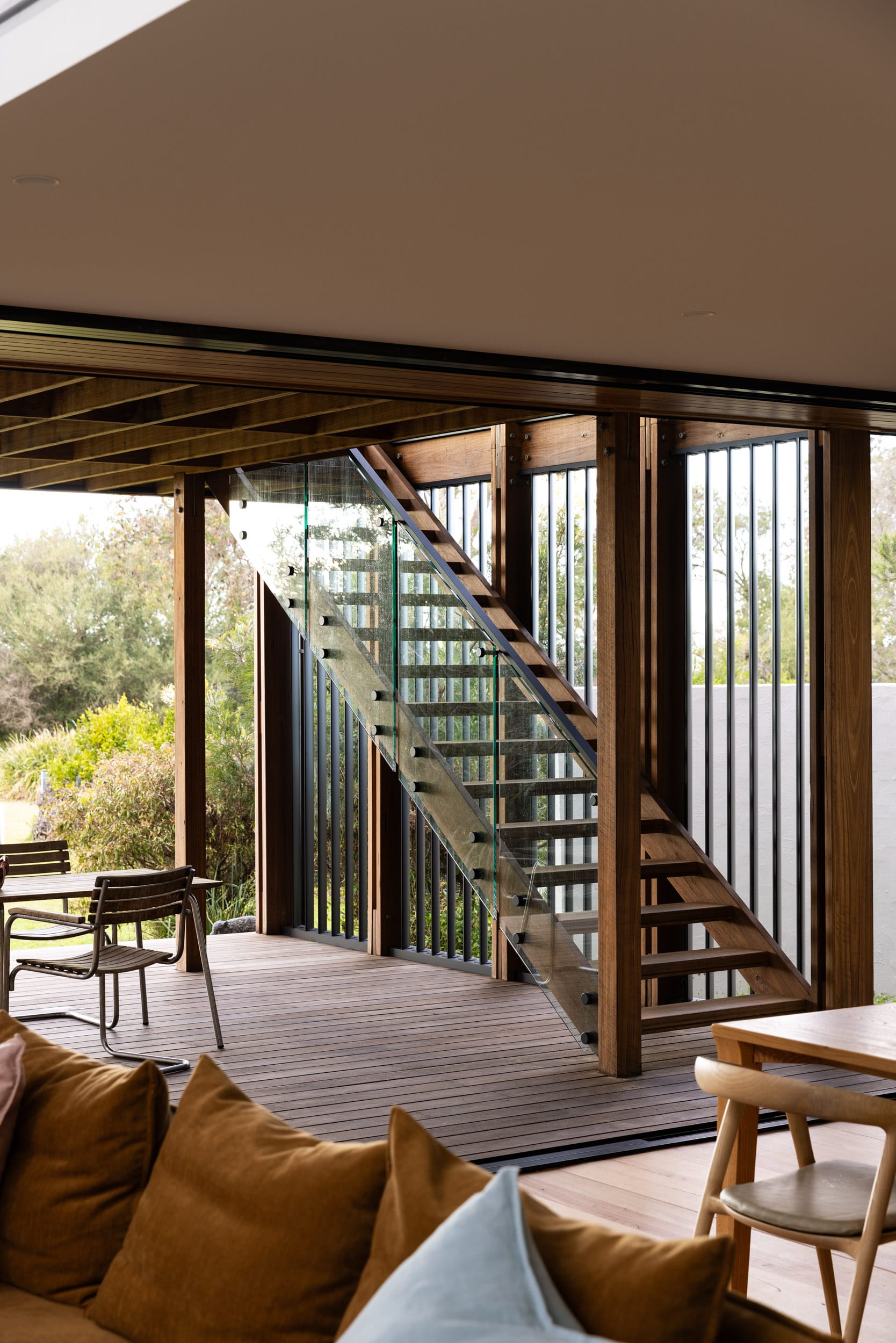 Bawley Point by Watershed Architects. Photography by Simon Whitbread. Outdoor timber deck with timber staircase with glass balustrade leading from lower deck to upper level. 