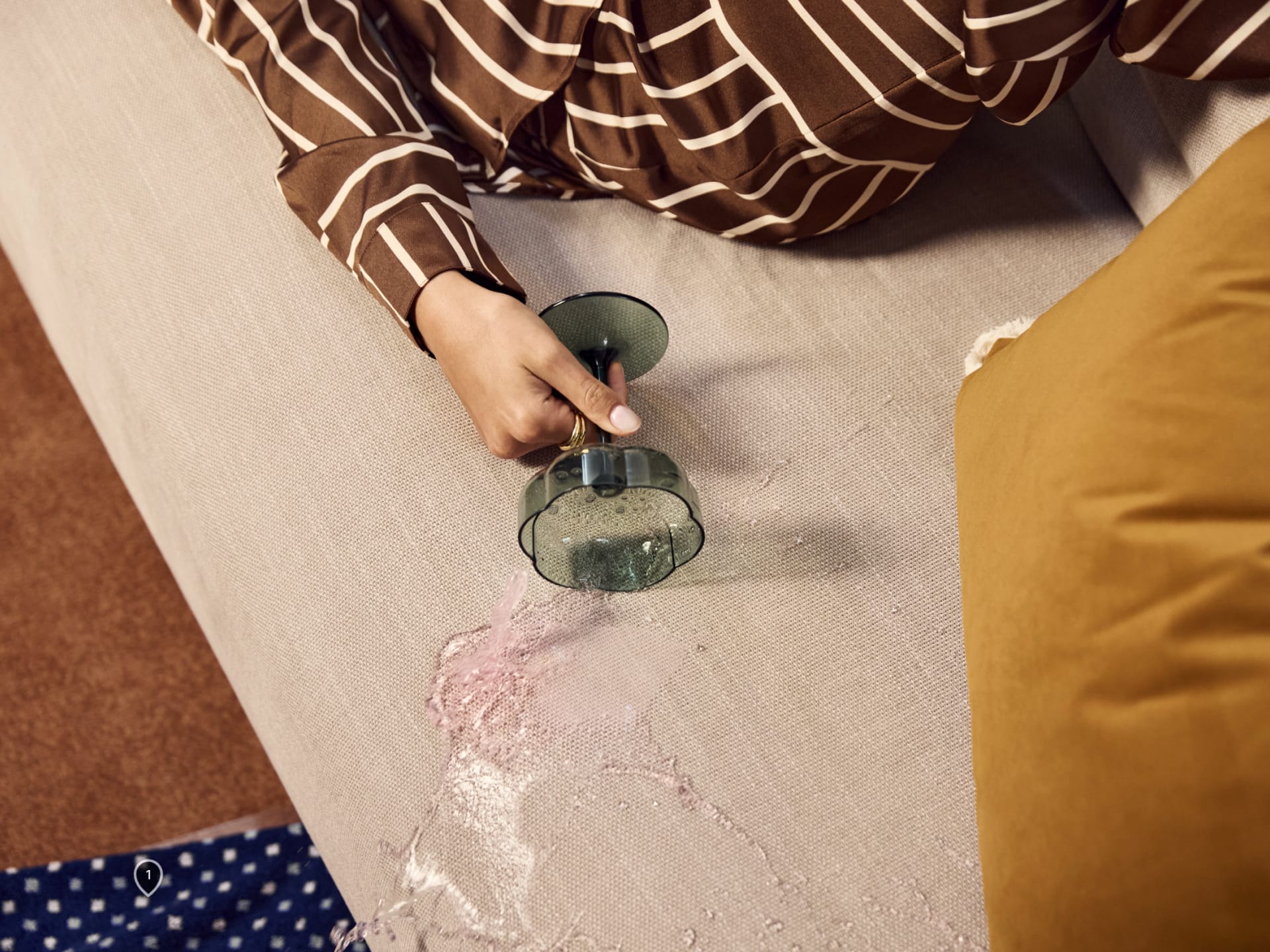 Koala Byron Sofa Bed [3rd Gen] in Lunar Glow. Beverage being spilled out of green glass onto light grey couch. 