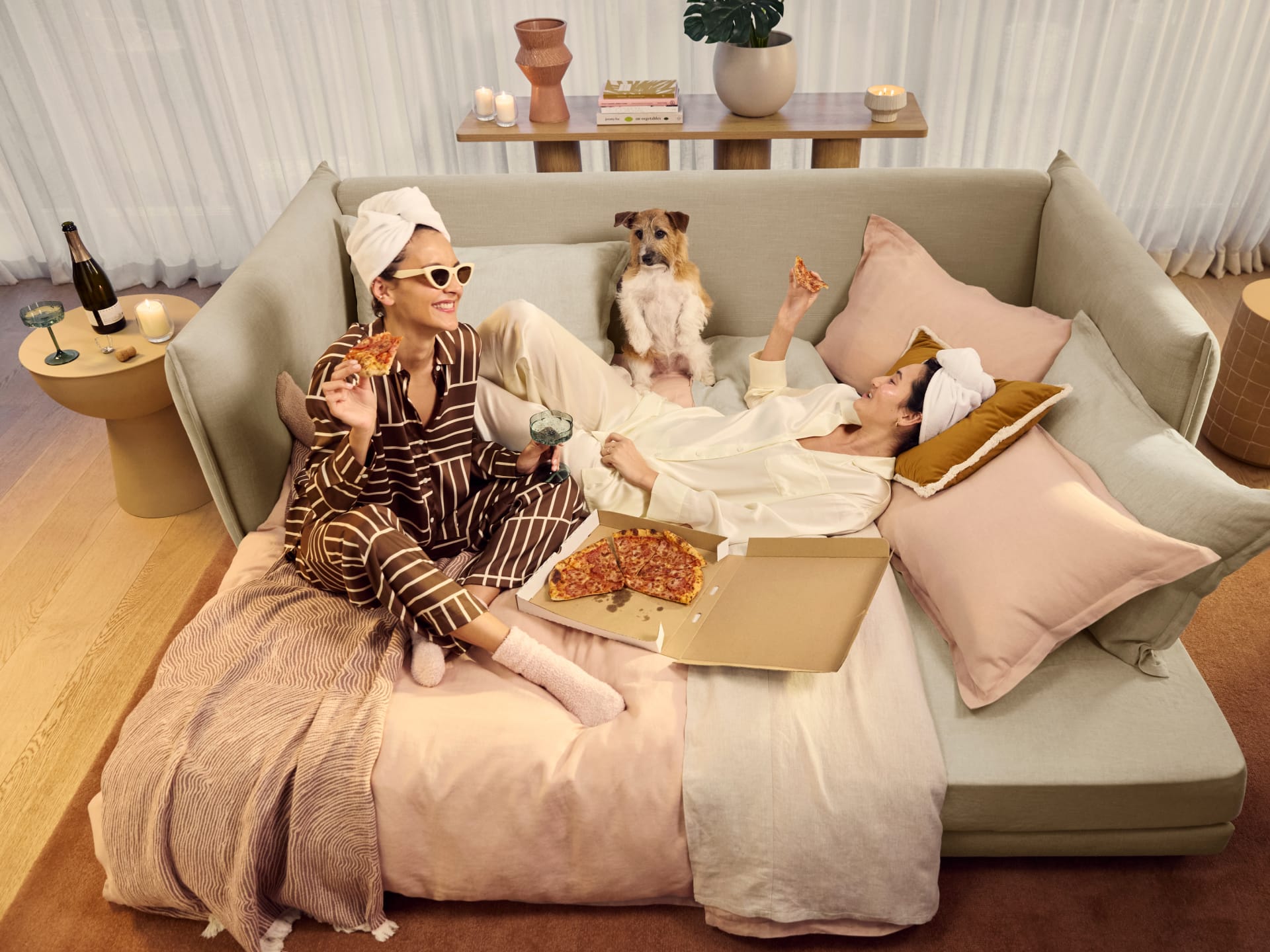 Koala Byron Sofa Bed [3rd Gen] in Lunar Glow. Beverage being spilled out of green glass onto light grey couch. 