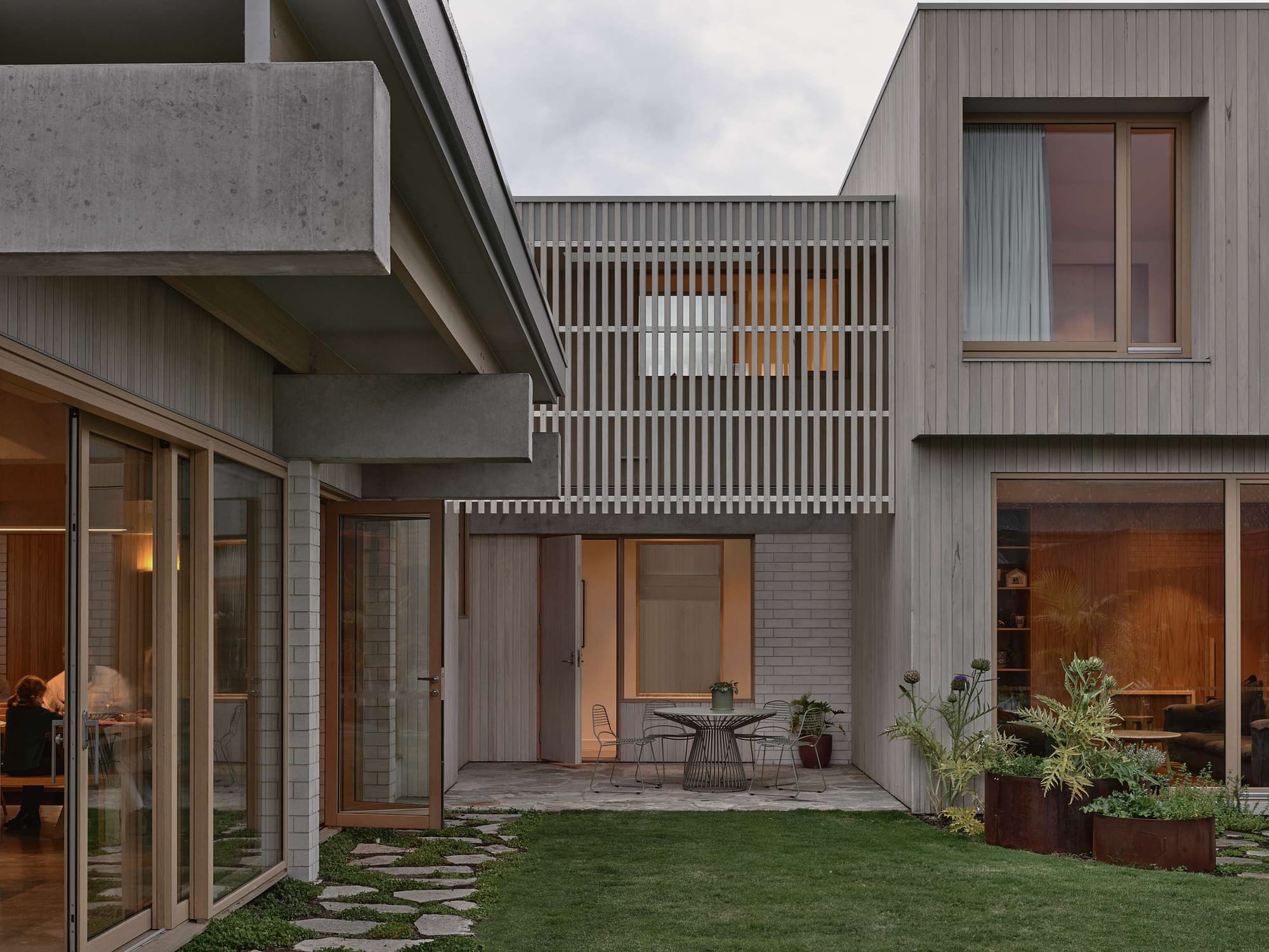 Home Pavilion by MRTN Architects. Grassed courtyard space framed on all sides by double storey contemporary home, with exposed brick, concrete and timber facade. 