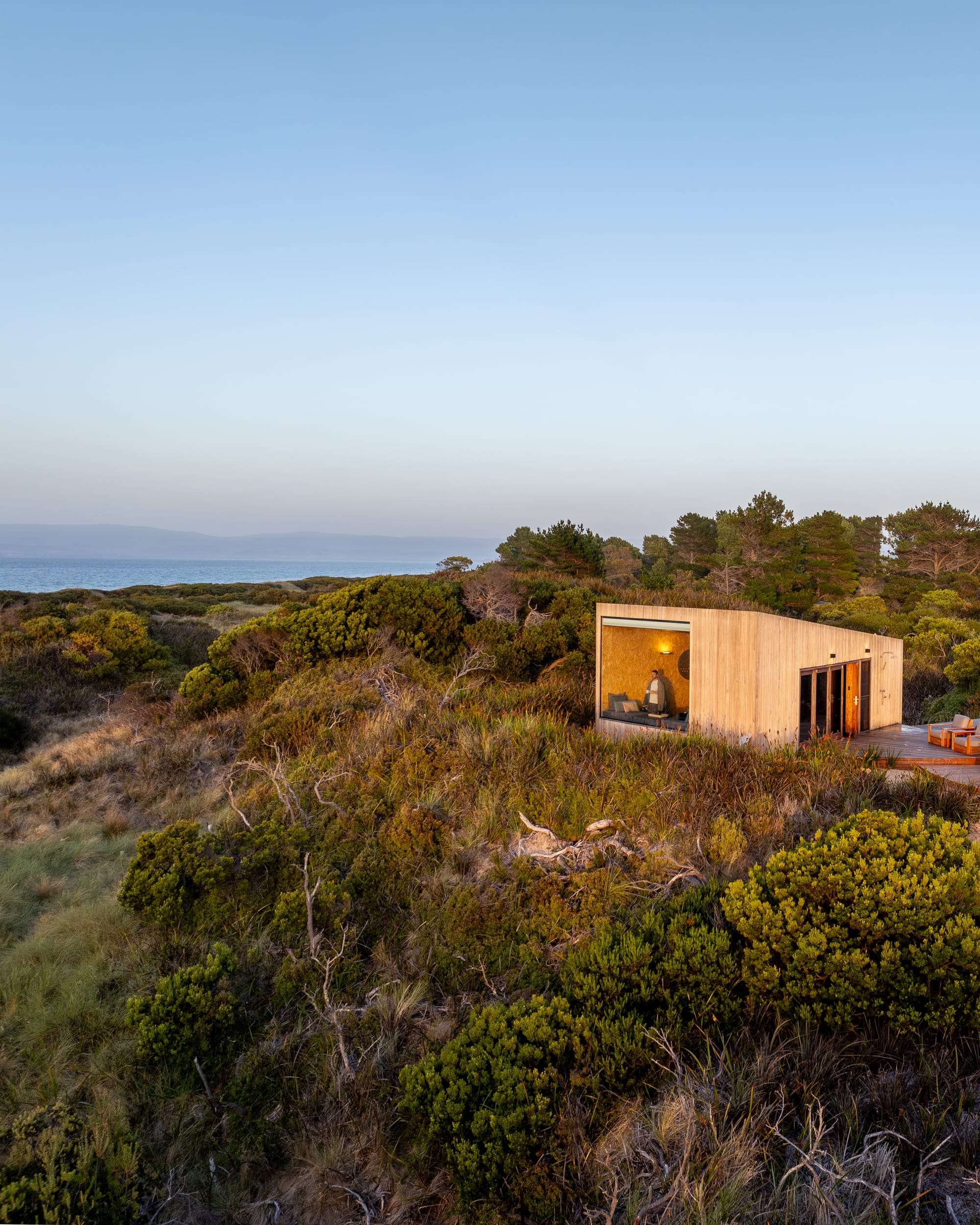 An exterior view showing the timber cladding and large picture window of Studio Tasmania.