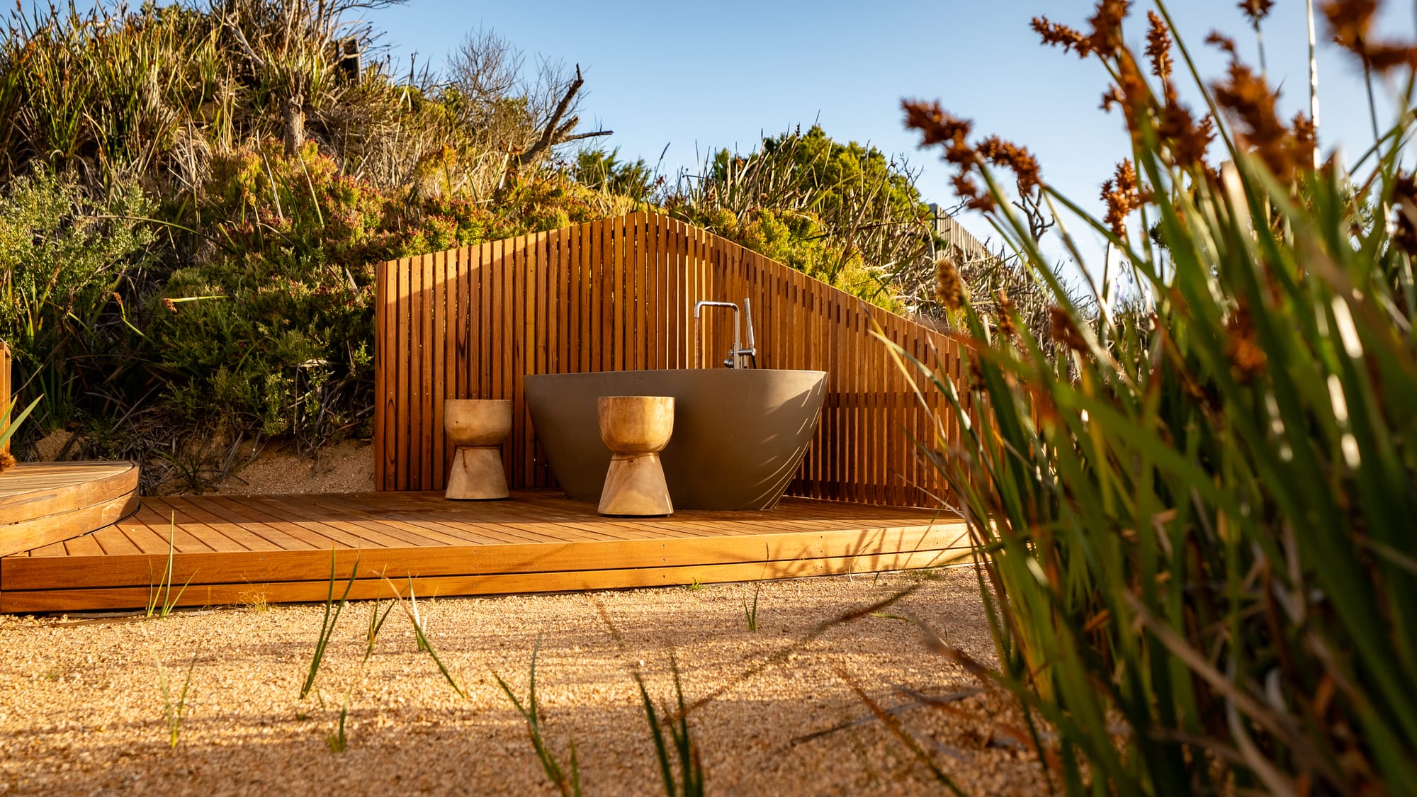 An external view of the outdoor bath at Studio Tasmania with the timber privacy screen.