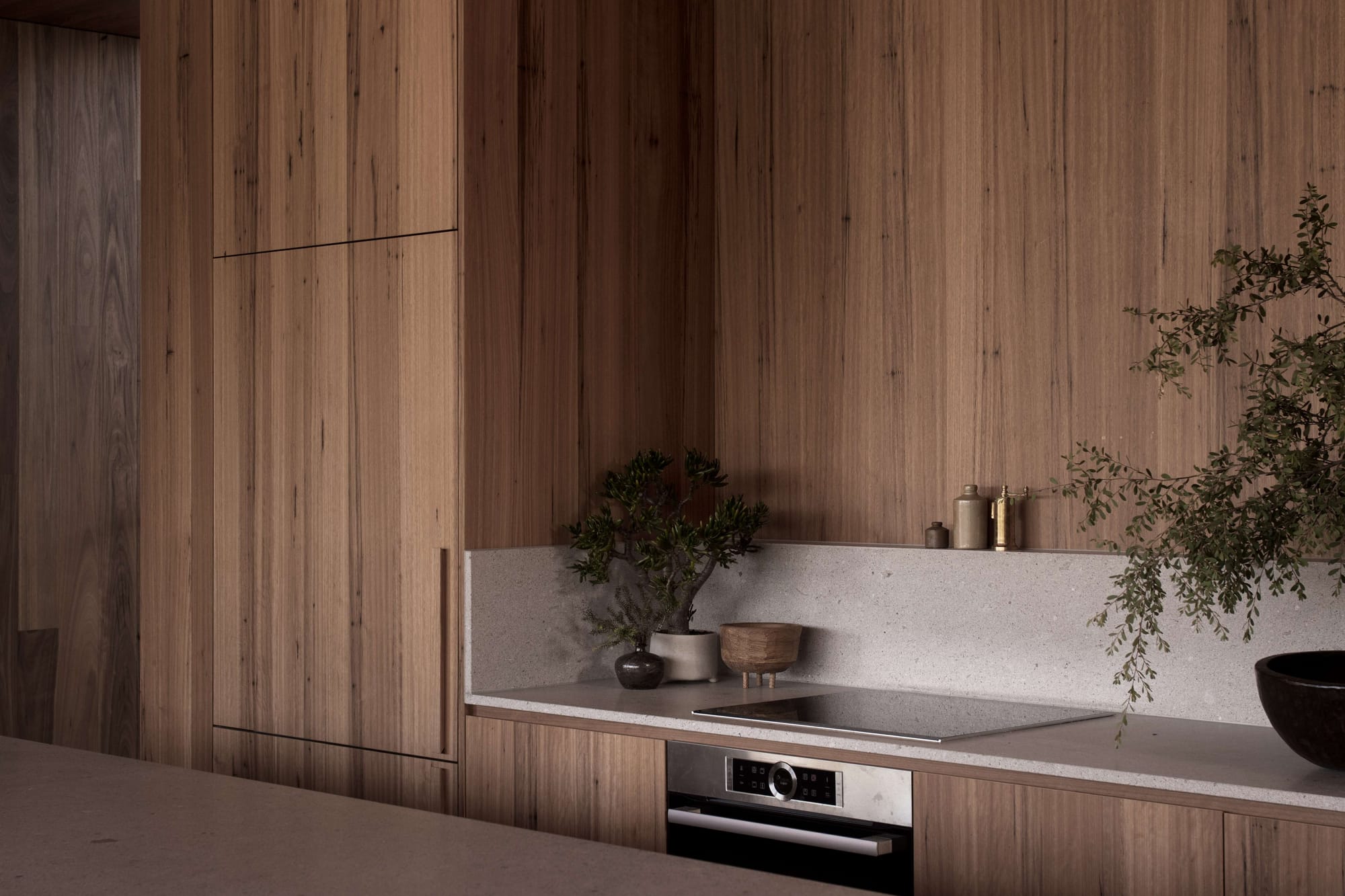 Point Lonsdale House by Edition Office. Photographed by Ben Hosking. Kitchen with wooden walls and wooden cabinet. Electrice stove top and oven.