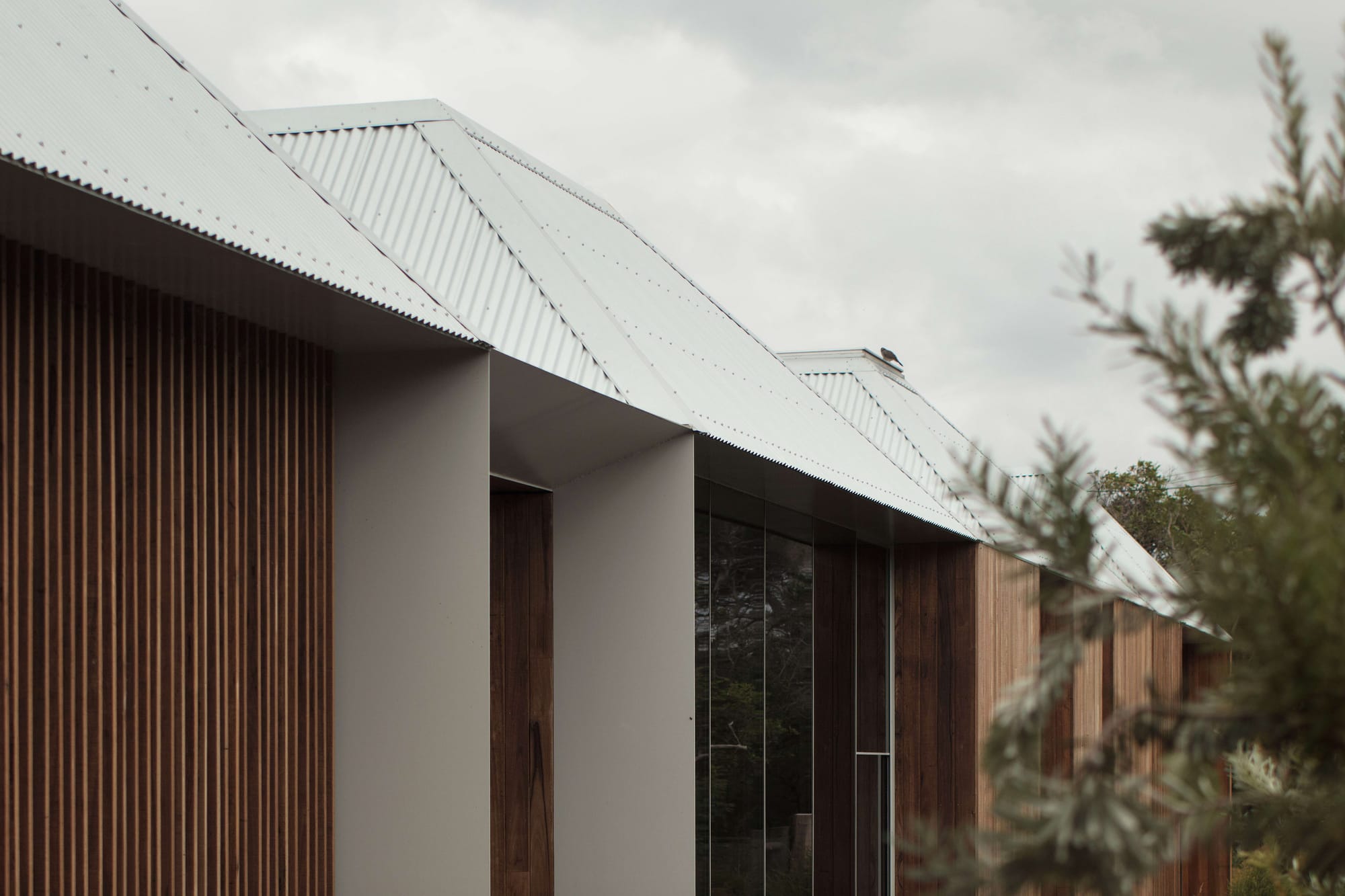 Point Lonsdale House by Edition Office. Photographed by Ben Hosking. Wooden exterior home with white roofs.