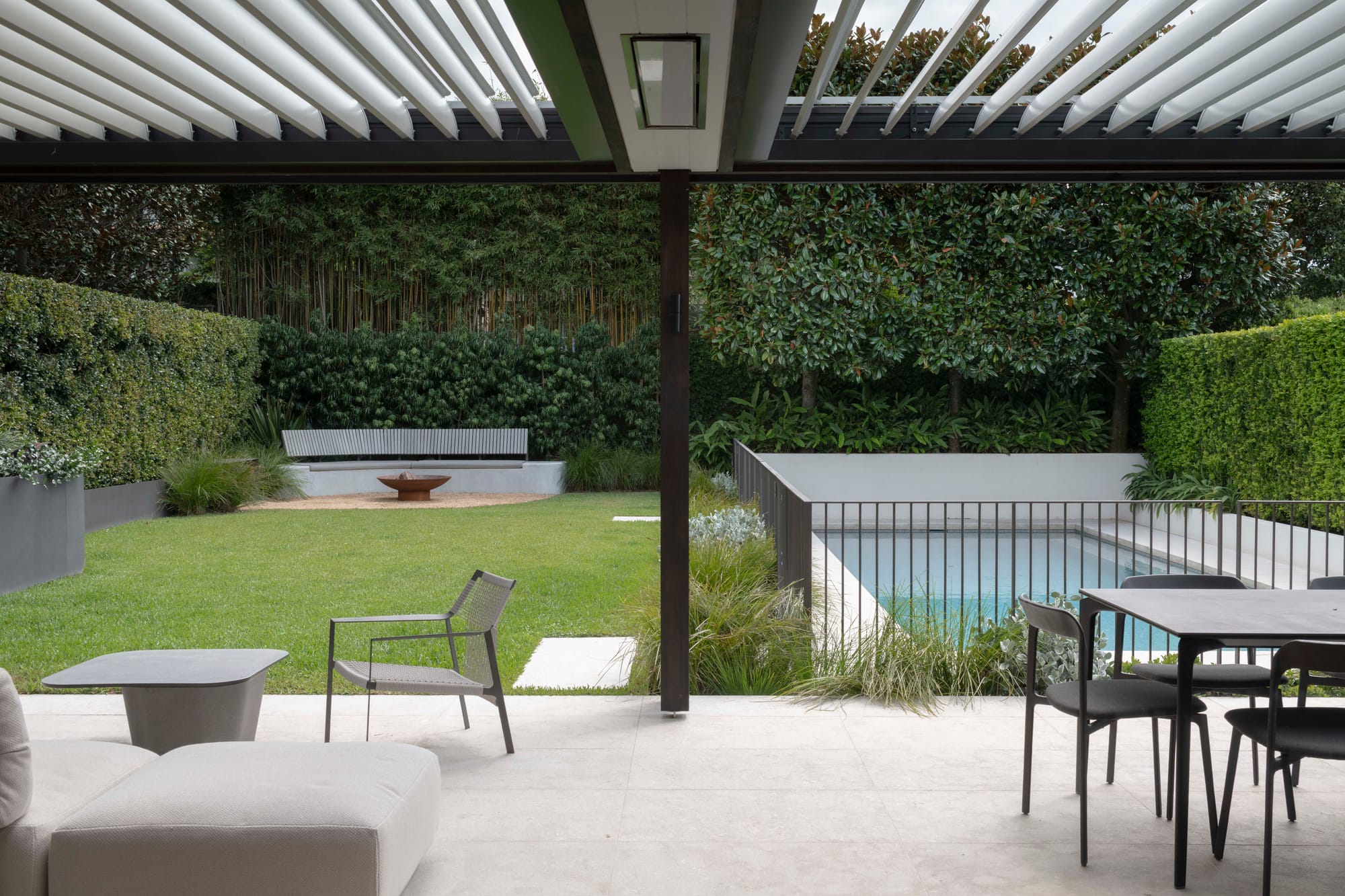 outdoor area with grey outdoor chairs and outdoor cream lounge seat. Outdoor grey dining set.