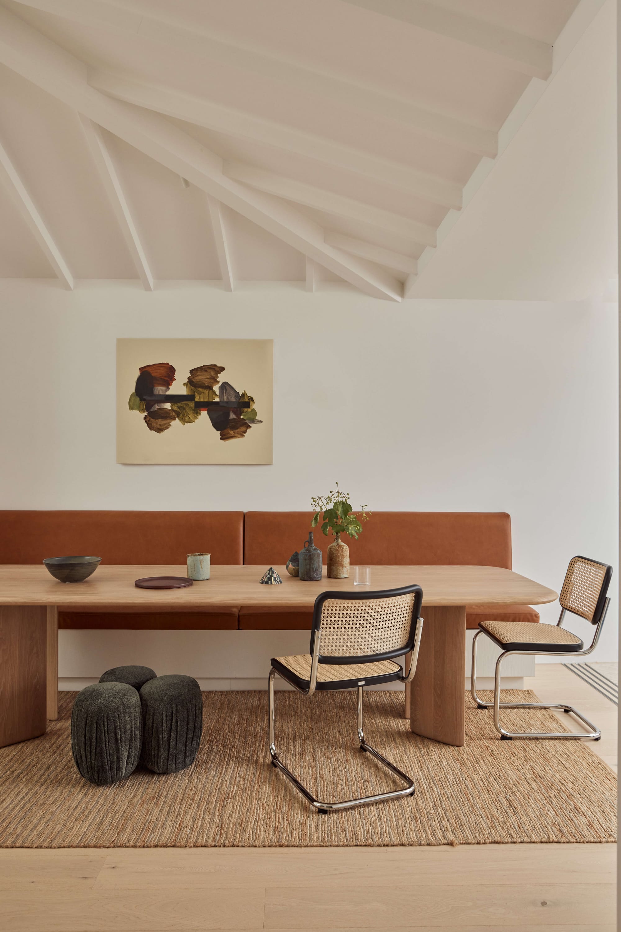 Seaside House by Carla Middleton Architecture. Photographed by Alana Landberry. Dinning area with curved edge wooden table. Orange booth seat and white walls