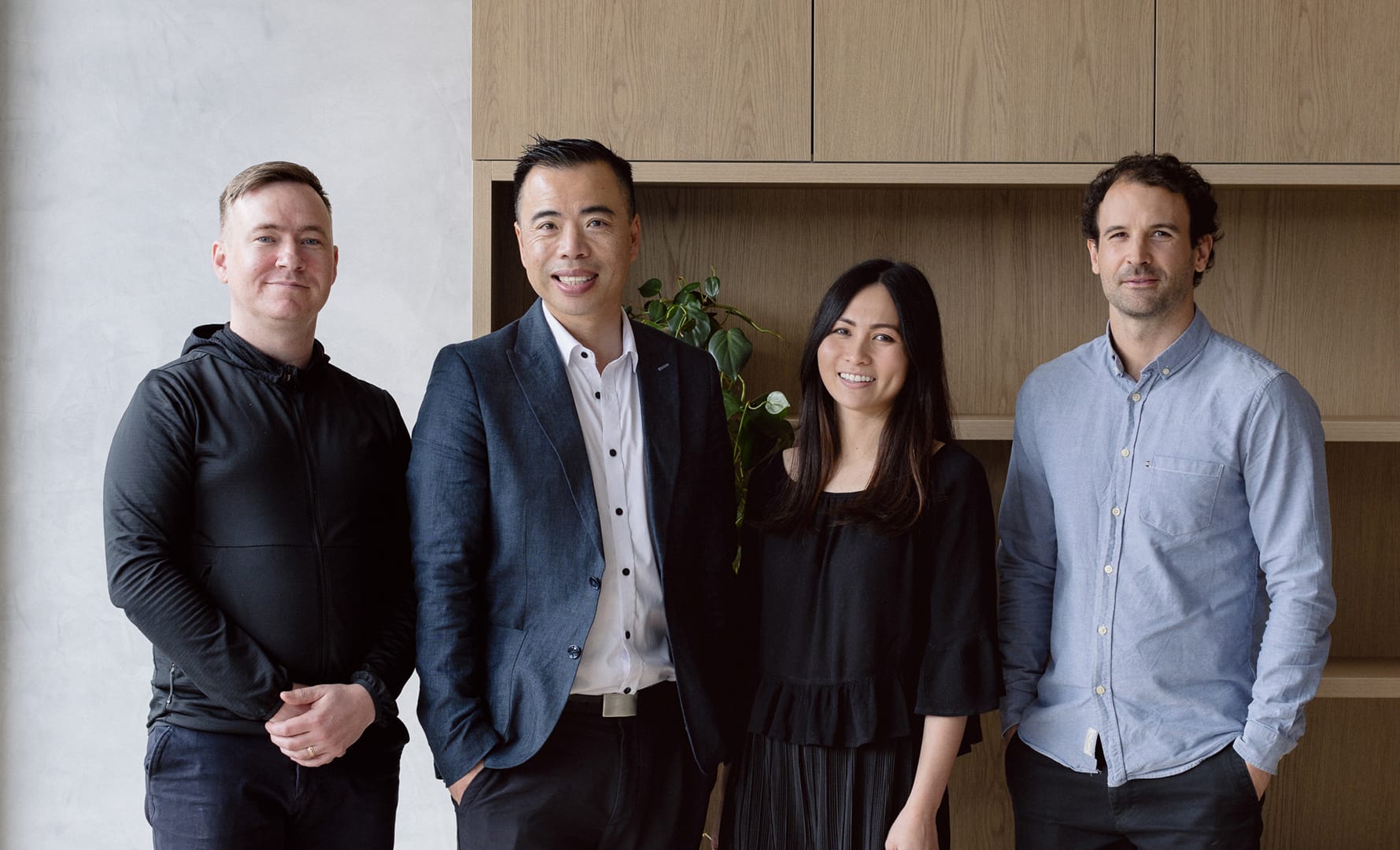 Group portrait of Chan Architecture team standing in a studio space with timber shelving backdrop.