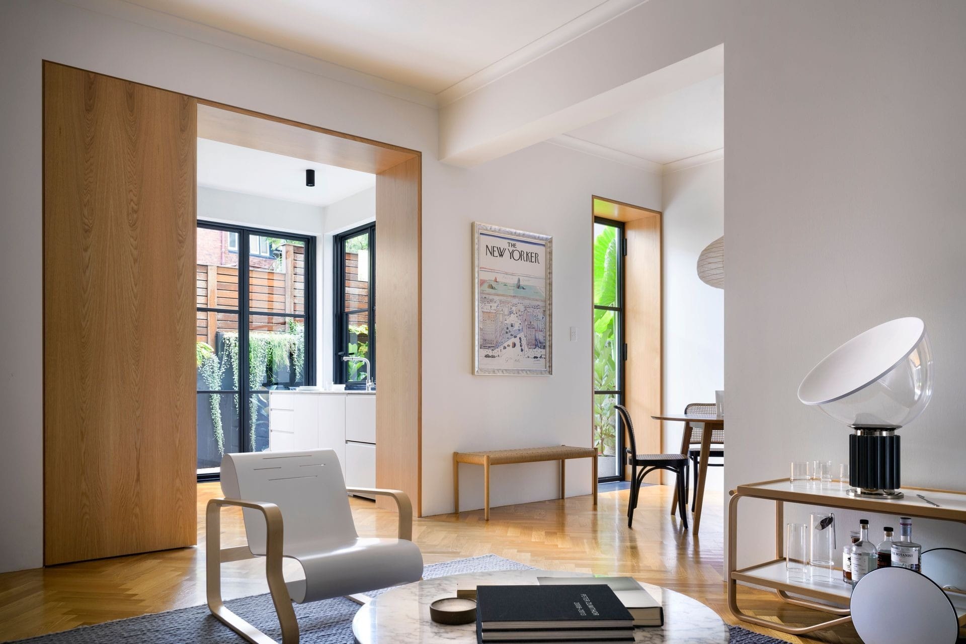 Open-plan living area with timber floors, framed doorway and natural light connecting to dining space