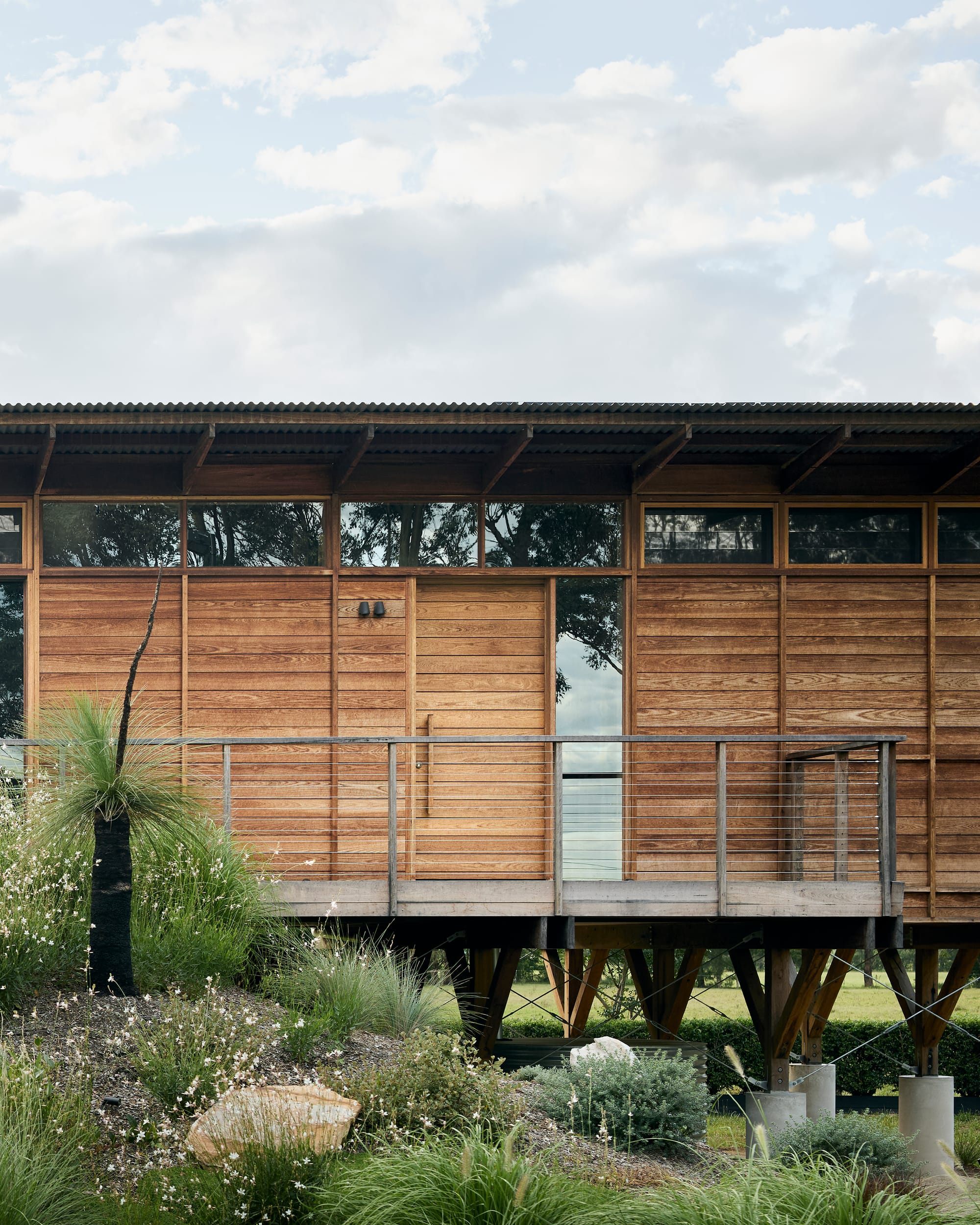 Close-up of a timber façade and elevated deck showcasing natural materials and lightweight structural detailing.