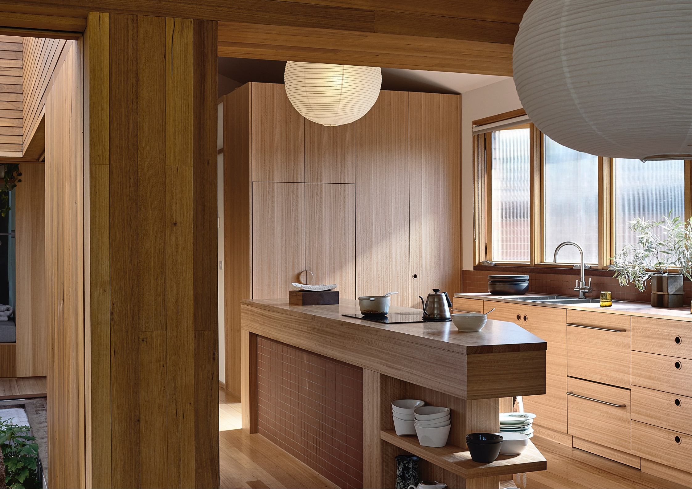 Timber-lined kitchen with Japanese-inspired detailing, open shelving, and warm natural materials throughout.