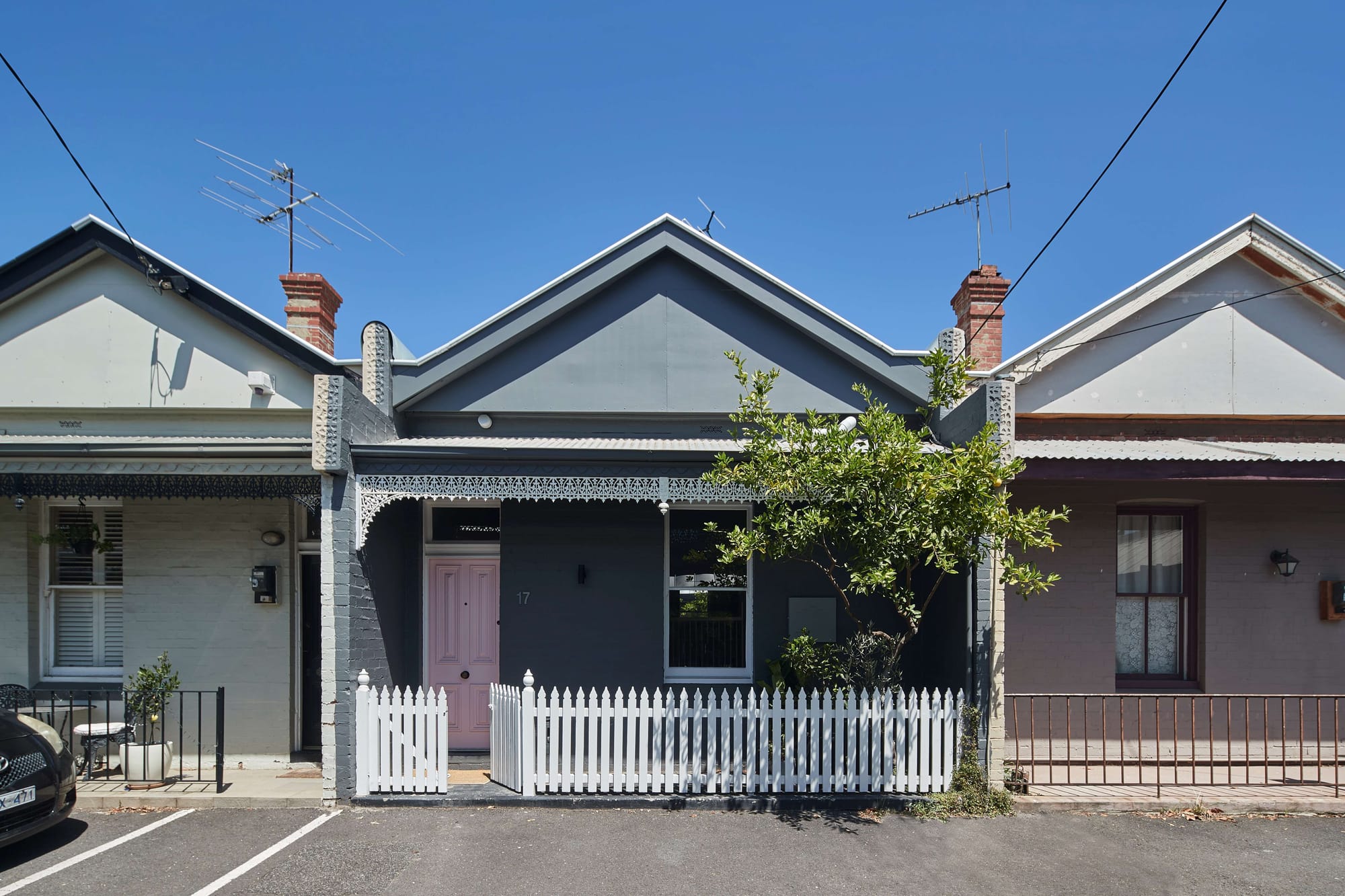 Street-facing facade of Little OG by McMahon & Nerlich in Albert Park, showing the retained Victorian cottage frontage with a pale pink door and white picket fence