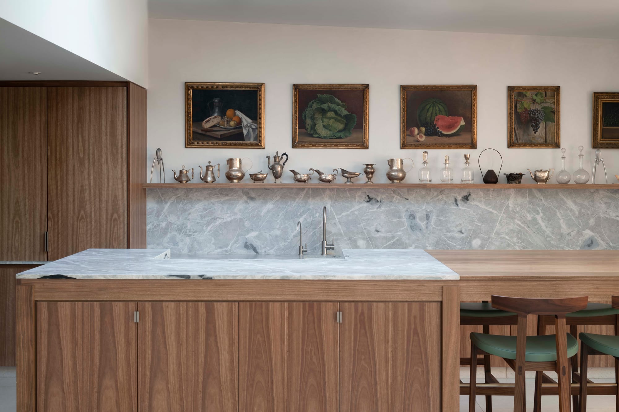Kitchen island in American oak and marble with collection of silverware and oil paintings above, Paddington Twin Terraces by Studio Dewar