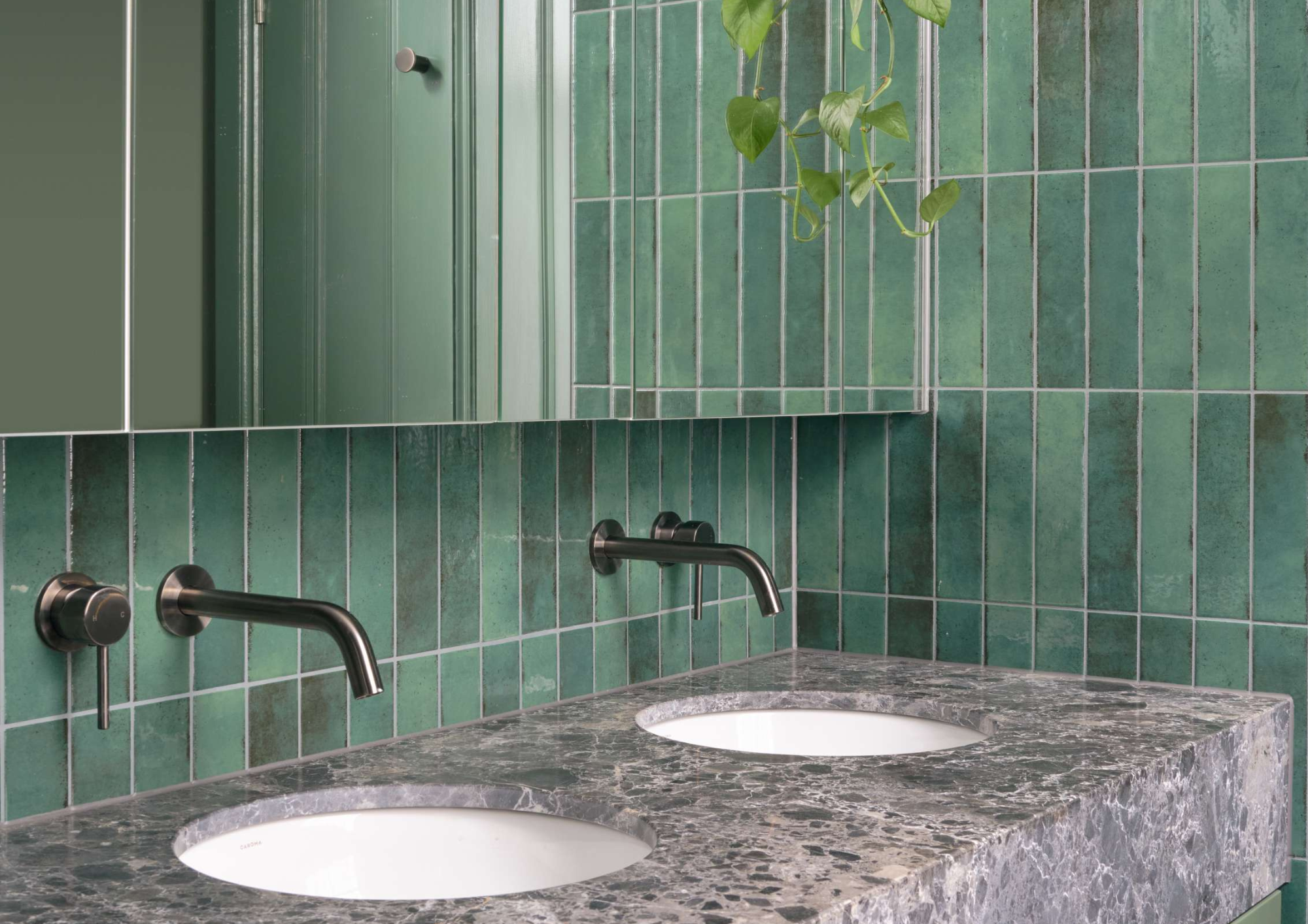 Bathroom detail in Peavey Residence II by FYC Architects featuring handmade green zellige tiles, a honed marble vanity and brushed gunmetal wall-mounted tapware