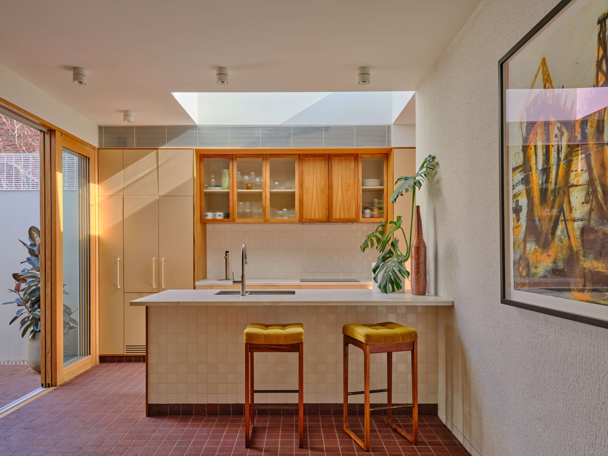 Kitchen with skylight framing tree branches, timber joinery and terracotta floor tiles, Fitzroy Duet by true story